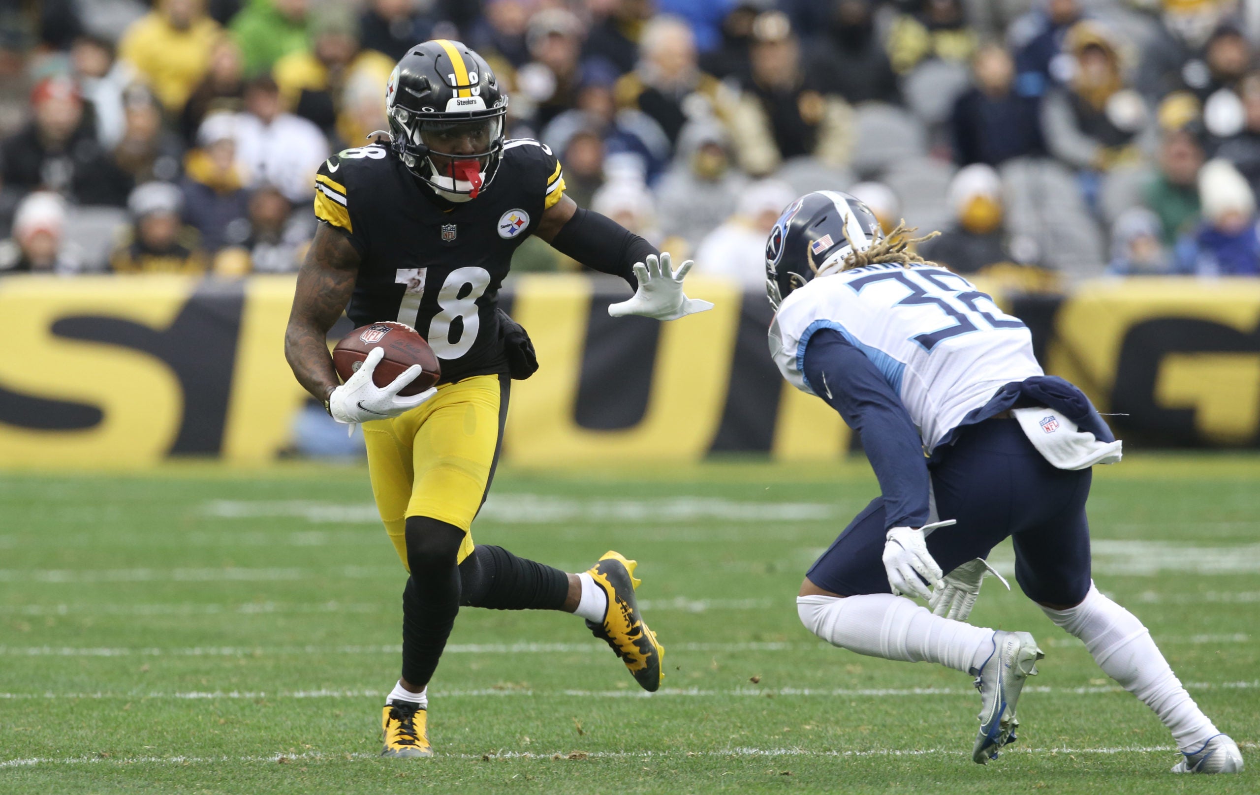 Dec 19, 2021; Pittsburgh, Pennsylvania, USA; Pittsburgh Steelers wide receiver Diontae Johnson (18) runs after a catch against Tennessee Titans cornerback Buster Skrine (38) during the first quarter at Heinz Field. Mandatory Credit: Charles LeClaire-USA TODAY Sports