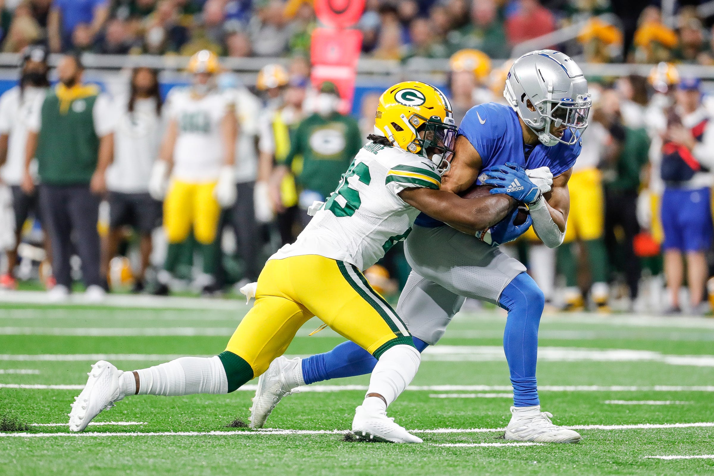 ions wide receiver Amon-Ra St. Brown is tackled by Packers free safety Darnell Savage during the first half on Sunday, Jan. 9, 2022, at Ford Field.