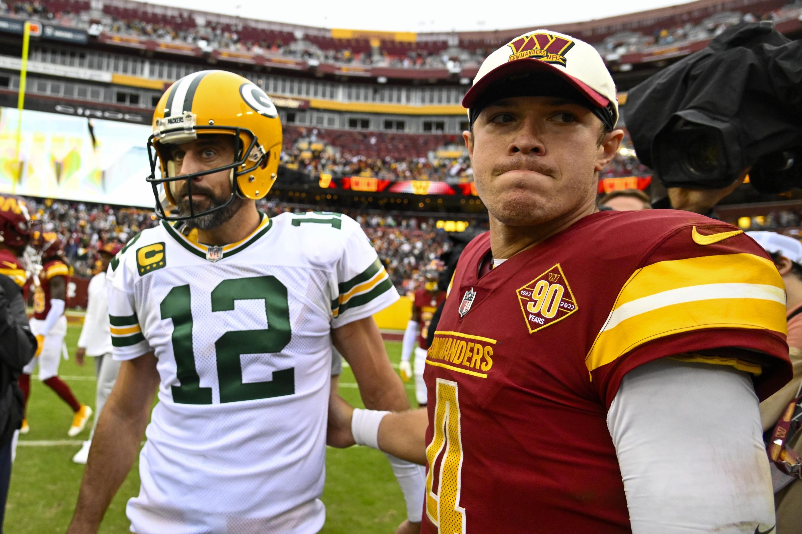 Oct 23, 2022; Landover, Maryland, USA; Green Bay Packers quarterback Aaron Rodgers (12) talks with Washington Commanders quarterback Taylor Heinicke (4) after the game at FedExField. Mandatory Credit: Brad Mills-USA TODAY Sports