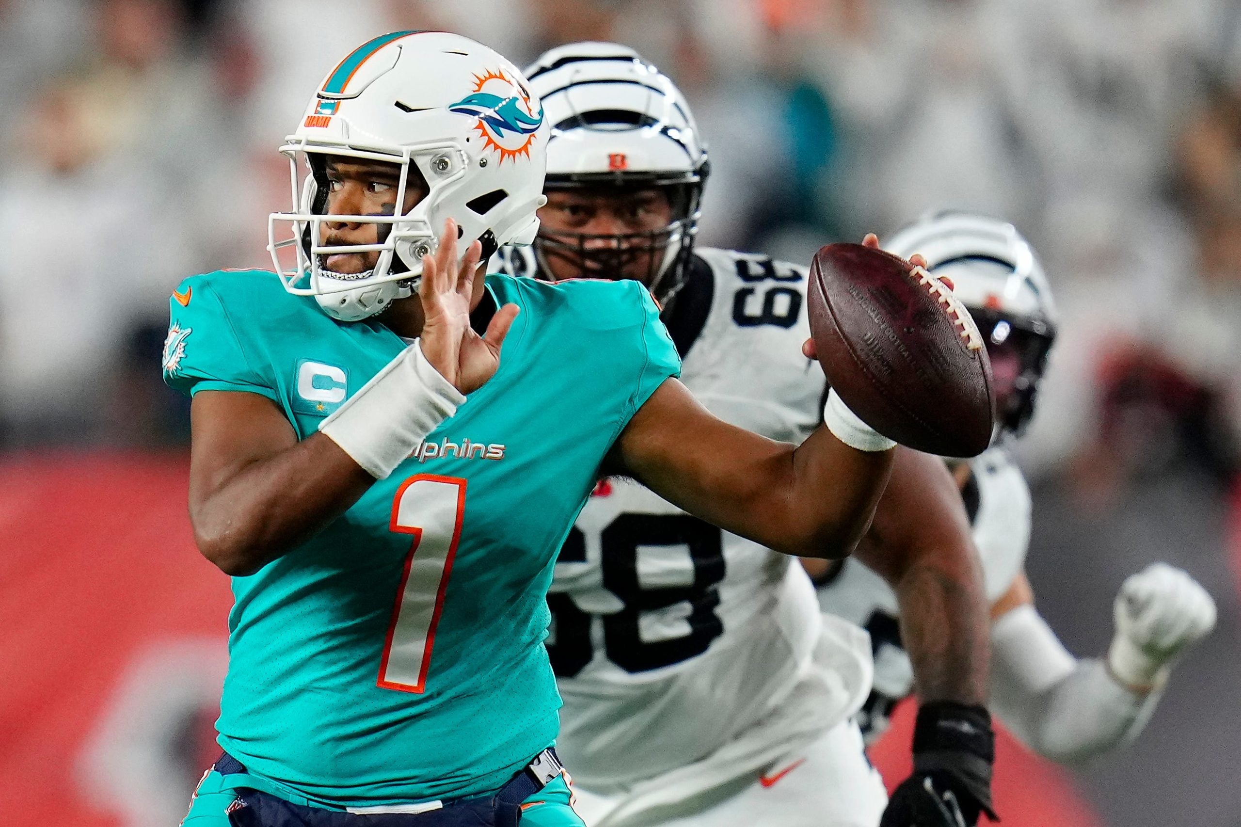 Miami Dolphins quarterback Tua Tagovailoa (1) is pursued by Cincinnati Bengals defensive tackle Josh Tupou (68) in the second quarter of the NFL Week 4 game between the Cincinnati Bengals and the Miami Dolphins at PayCor Stadium in downtown on Thursday, Sept. 29, 2022. The Bengals 14-12 at halftime. Miami Dolphins At Cincinnati Bengals Week 4