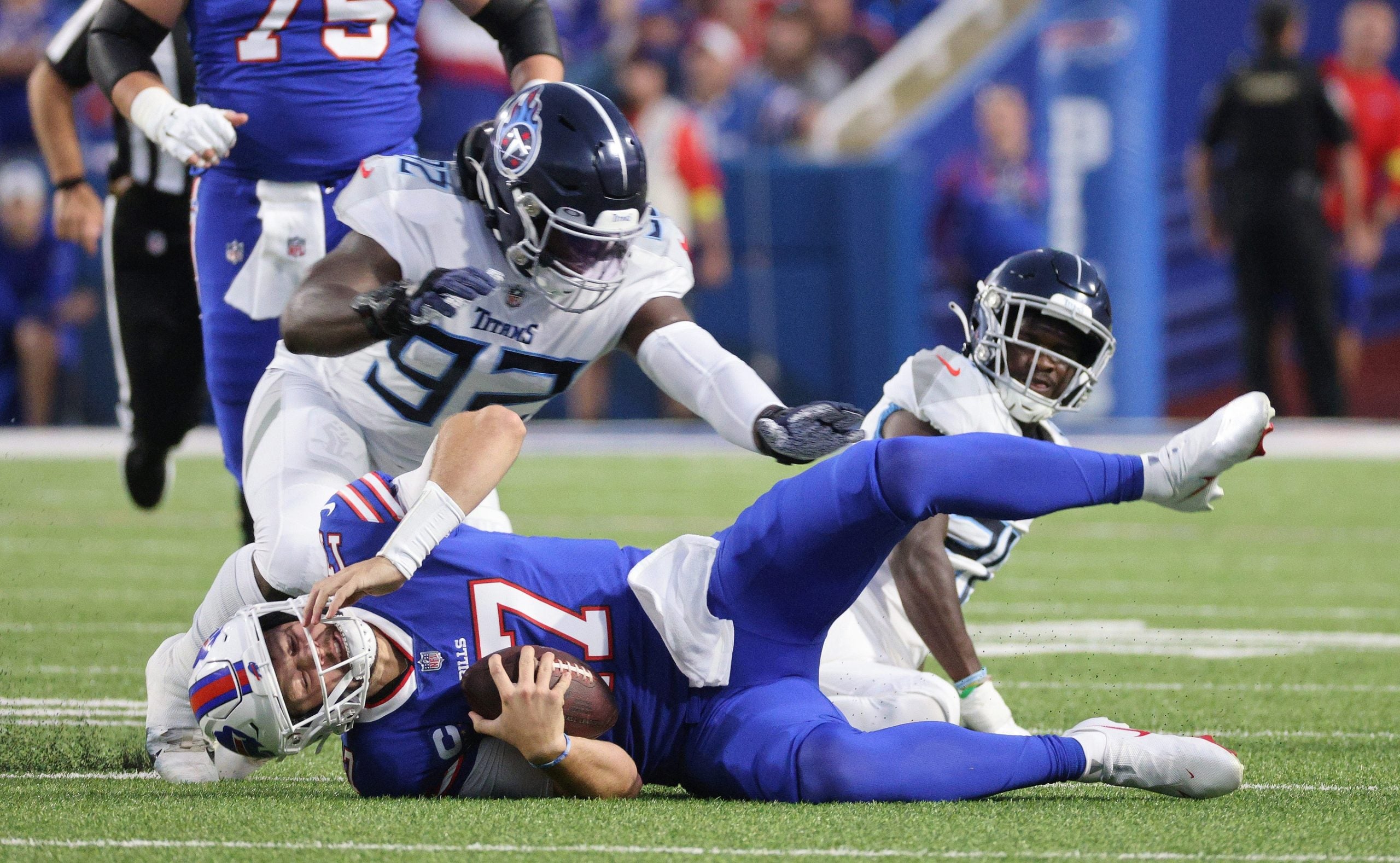 Bills quarterback Josh Allen lands hard after jumping over a Titans tackler. Mandatory Credit: JAMIE GERMANO-USA TODAY NETWORK