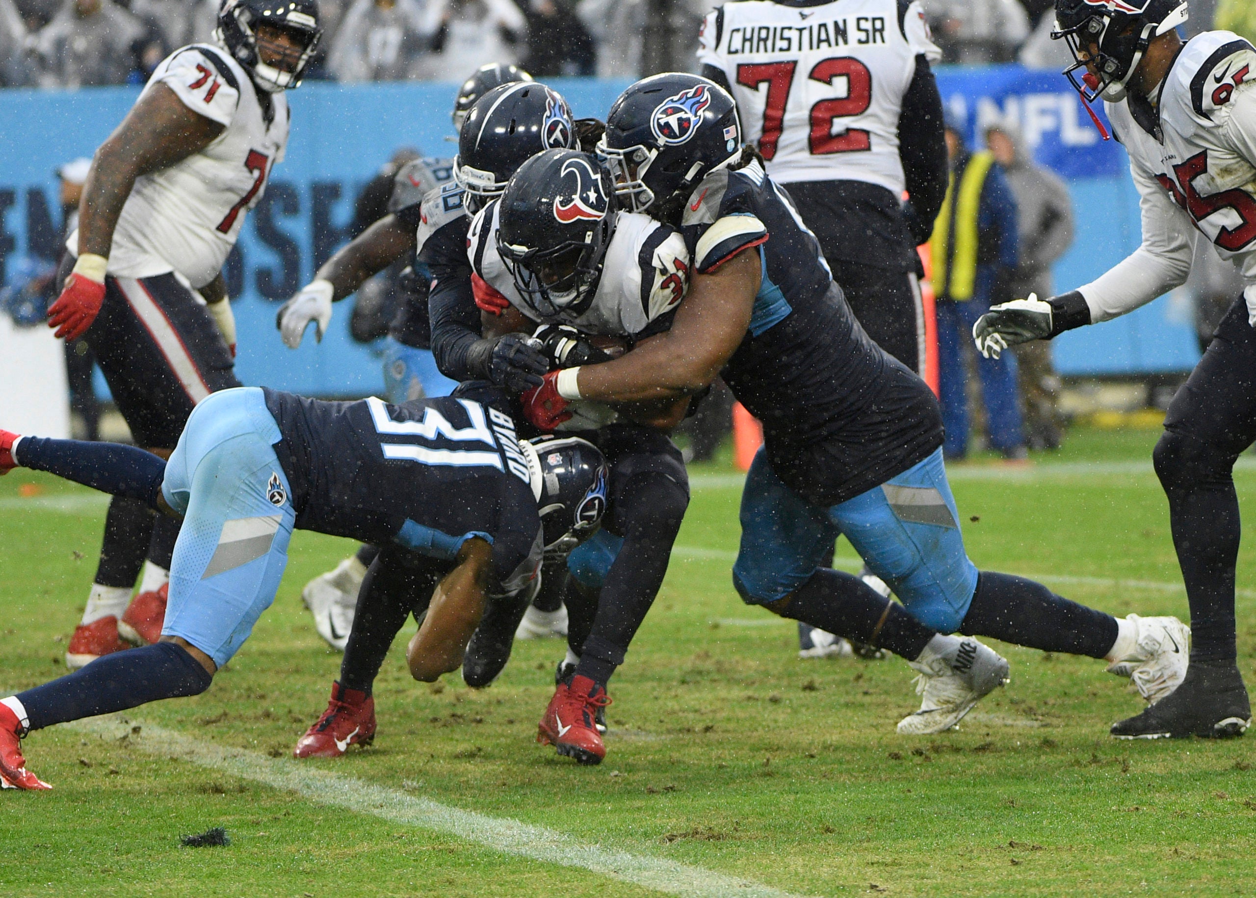 Nov 21, 2021; Nashville, Tennessee, USA;  Tennessee Titans free safety Kevin Byard (31) and Tennessee Titans defensive tackle Jeffery Simmons (98) tackle Houston Texans running back David Johnson (31) just after he crosses out of the end zone during the second half at Nissan Stadium. Mandatory Credit: Steve Roberts-USA TODAY Sports