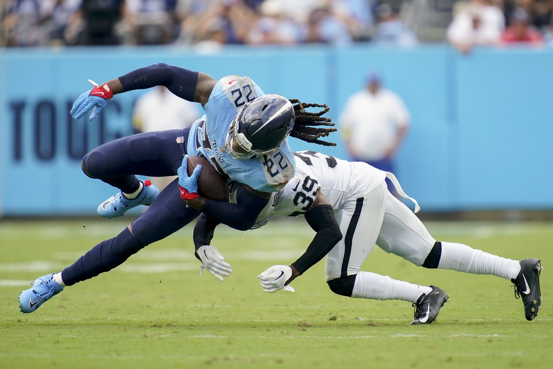 Sep 25, 2022; Nashville, Tennessee, USA; Tennessee Titans running back Derrick Henry (22) is hit by Las Vegas Raiders cornerback Nate Hobbs (39) at Nissan Stadium. Mandatory Credit: Andrew Nelles-USA TODAY Sports