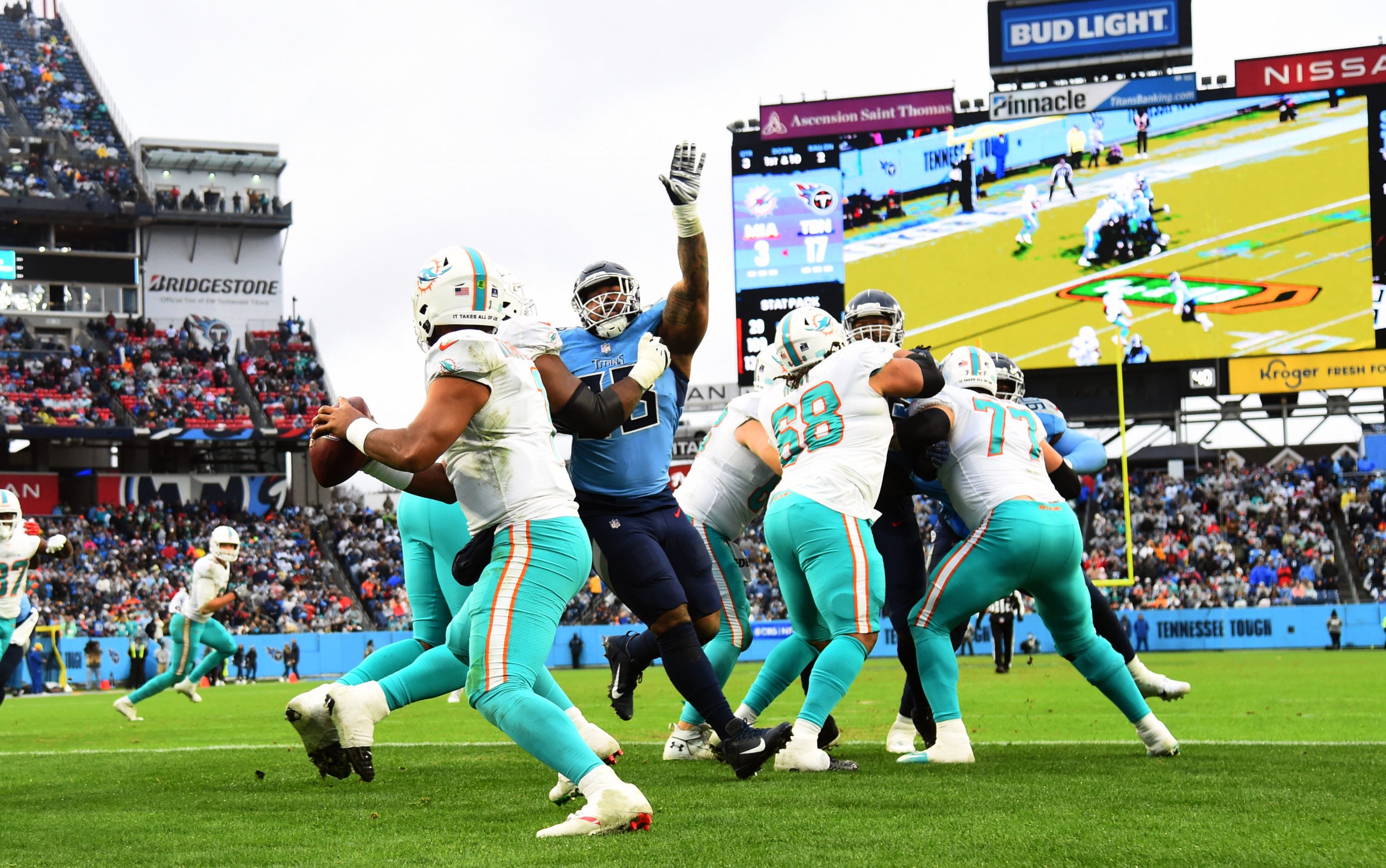 Jan 2, 2022; Nashville, Tennessee, USA; Miami Dolphins quarterback Tua Tagovailoa (1) scrambles in the pocket before pressure from Tennessee Titans defensive end Jeffery Simmons (98) during the second half at Nissan Stadium. Mandatory Credit: Christopher Hanewinckel-USA TODAY Sports