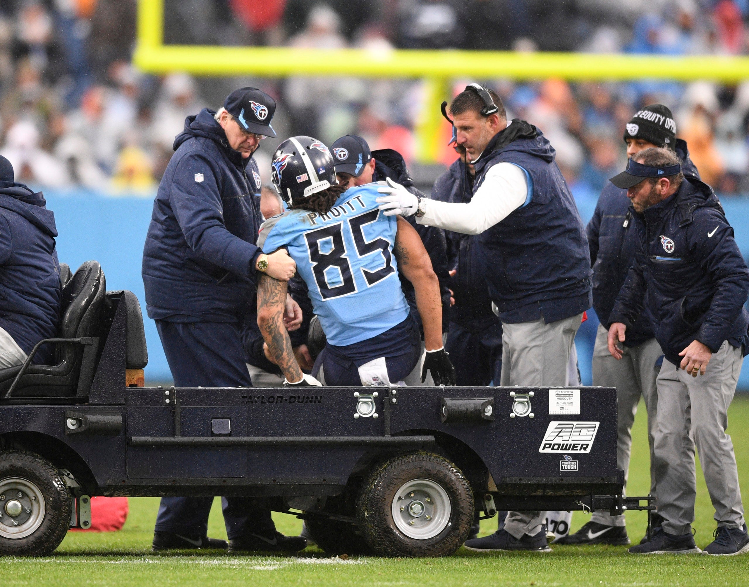 Jan 2, 2022; Nashville, Tennessee, USA;  Tennessee Titans head coach Mike Vrabel helps tight end McCole Pruitt (85) onto the cart against the Miami Dolphins during the first half at Nissan Stadium. Mandatory Credit: Steve Roberts-USA TODAY Sports