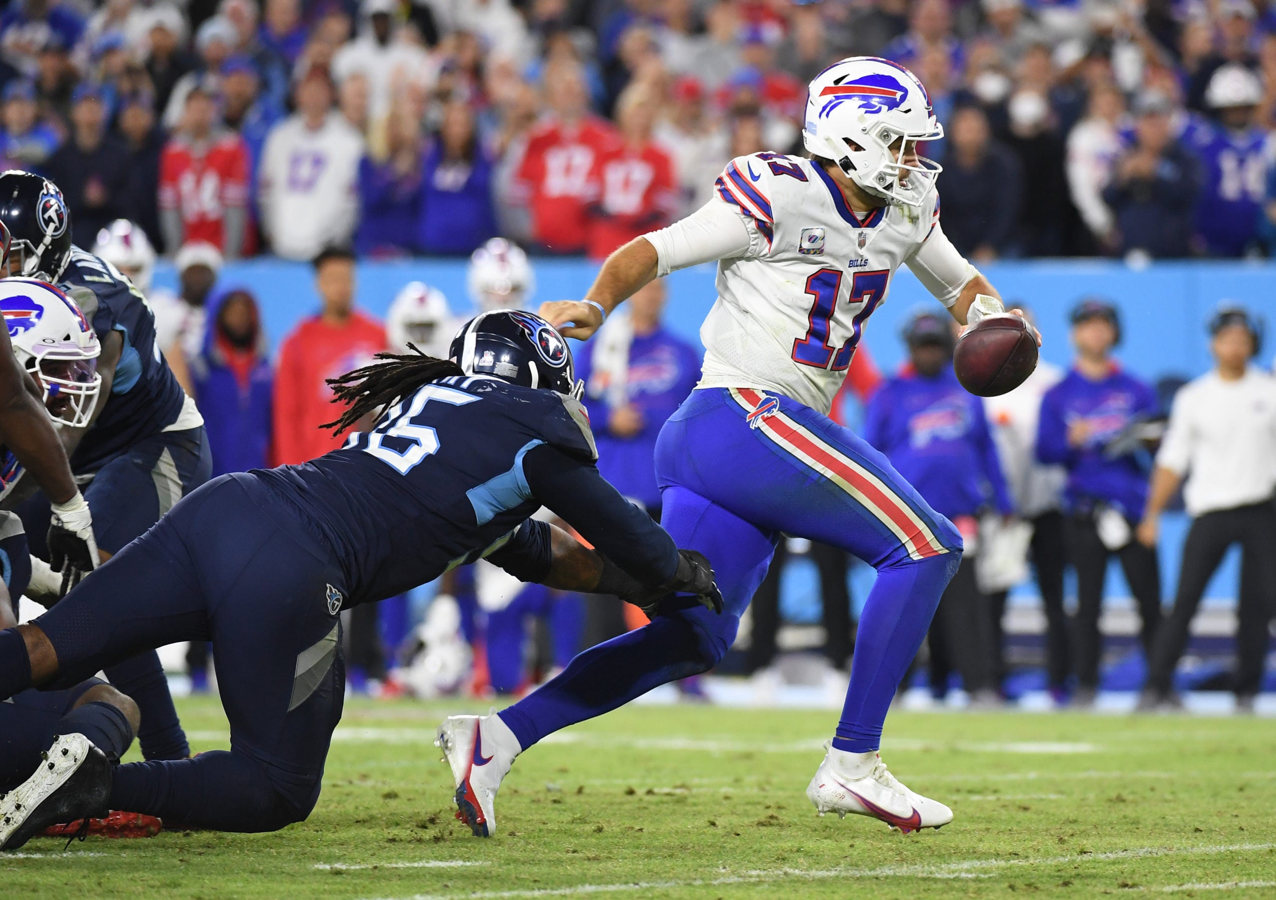 Oct 18, 2021; Nashville, Tennessee, USA; Buffalo Bills quarterback Josh Allen (17) scrambles out of the pocket from Tennessee Titans defensive end Denico Autry (96) during the second half at Nissan Stadium. Mandatory Credit: Christopher Hanewinckel-USA TODAY Sports