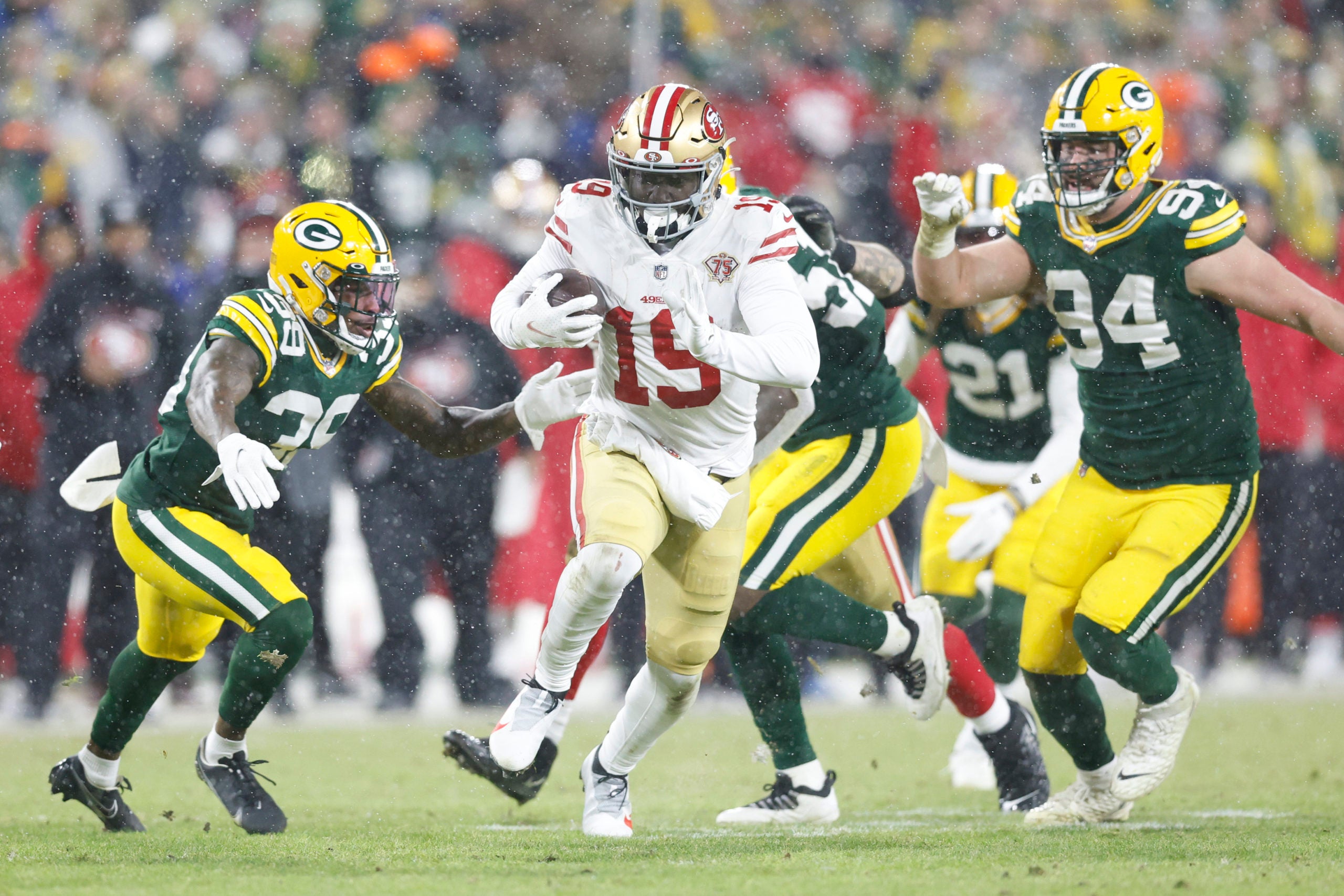 Jan 22, 2022; Green Bay, Wisconsin, USA; San Francisco 49ers wide receiver Deebo Samuel (19) carries the ball past Green Bay Packers defensive end Dean Lowry (94) and Packers defensive back Chandon Sullivan (39) in the third quarter during a NFC Divisional playoff football game at Lambeau Field. Mandatory Credit: Jeff Hanisch-USA TODAY Sports