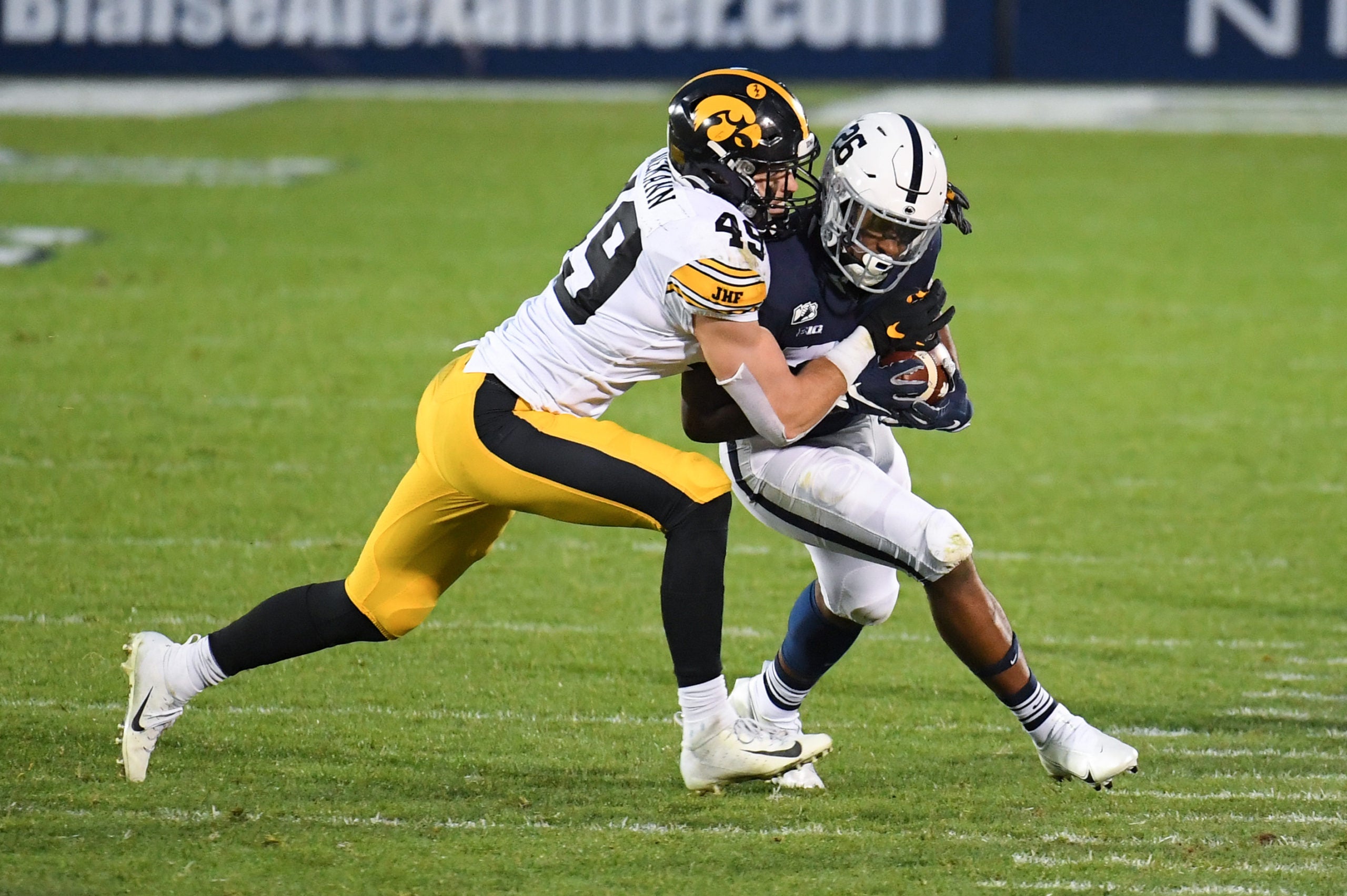 Nov 21, 2020; University Park, Pennsylvania, USA; Iowa Hawkeyes linebacker Nick Niemann (49) tackles Penn State Nittany Lions running back Caziah Holmes (26) during the second quarter at Beaver Stadium. Mandatory Credit: Rich Barnes-USA TODAY Sports