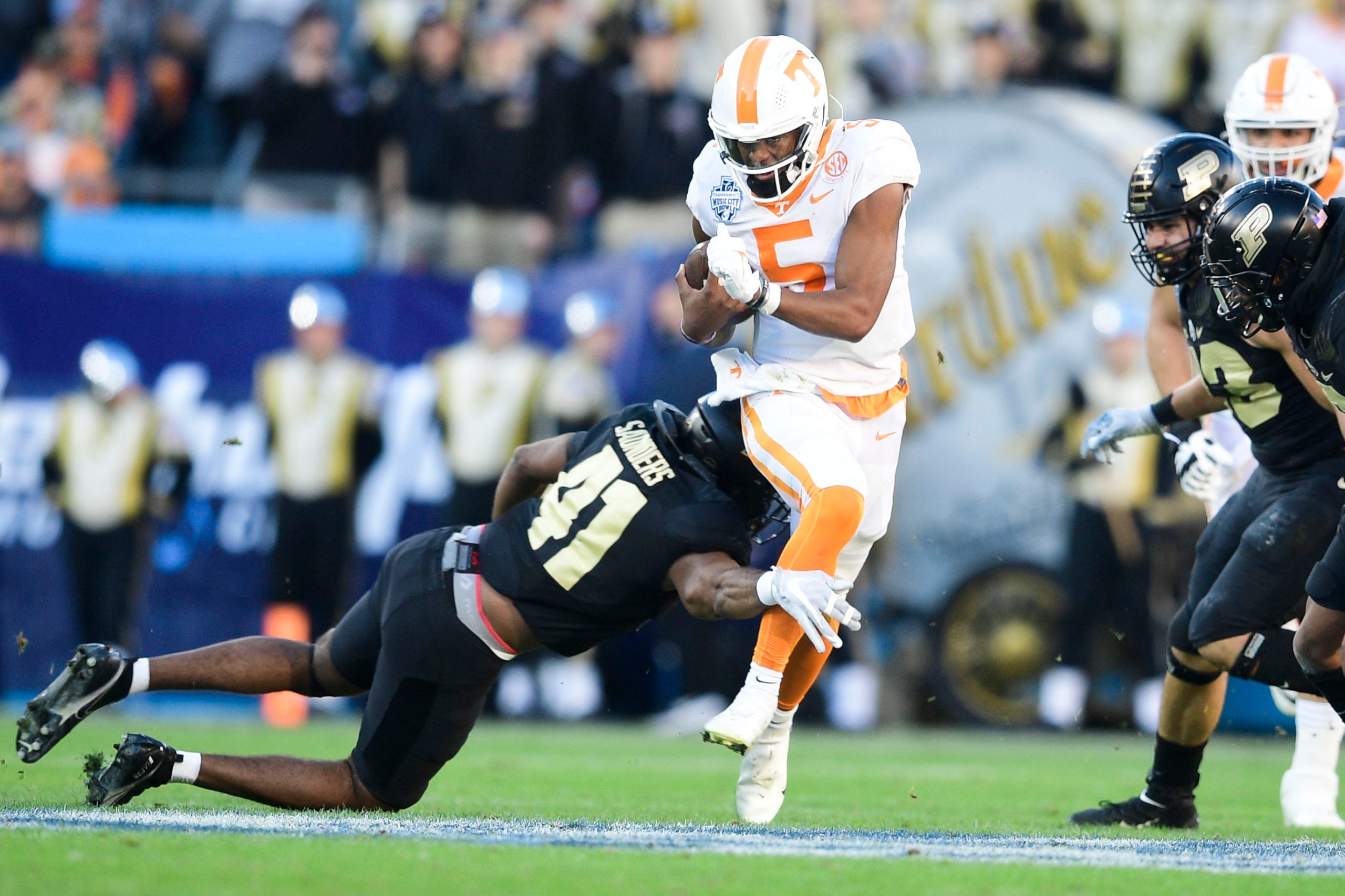 Tennessee quarterback Hendon Hooker (5) dodges Purdue linebacker Khali Saunders (41) at the 2021 Music City Bowl NCAA college football game at Nissan Stadium in Nashville, Tenn. on Thursday, Dec. 30, 2021. Kns Tennessee Purdue