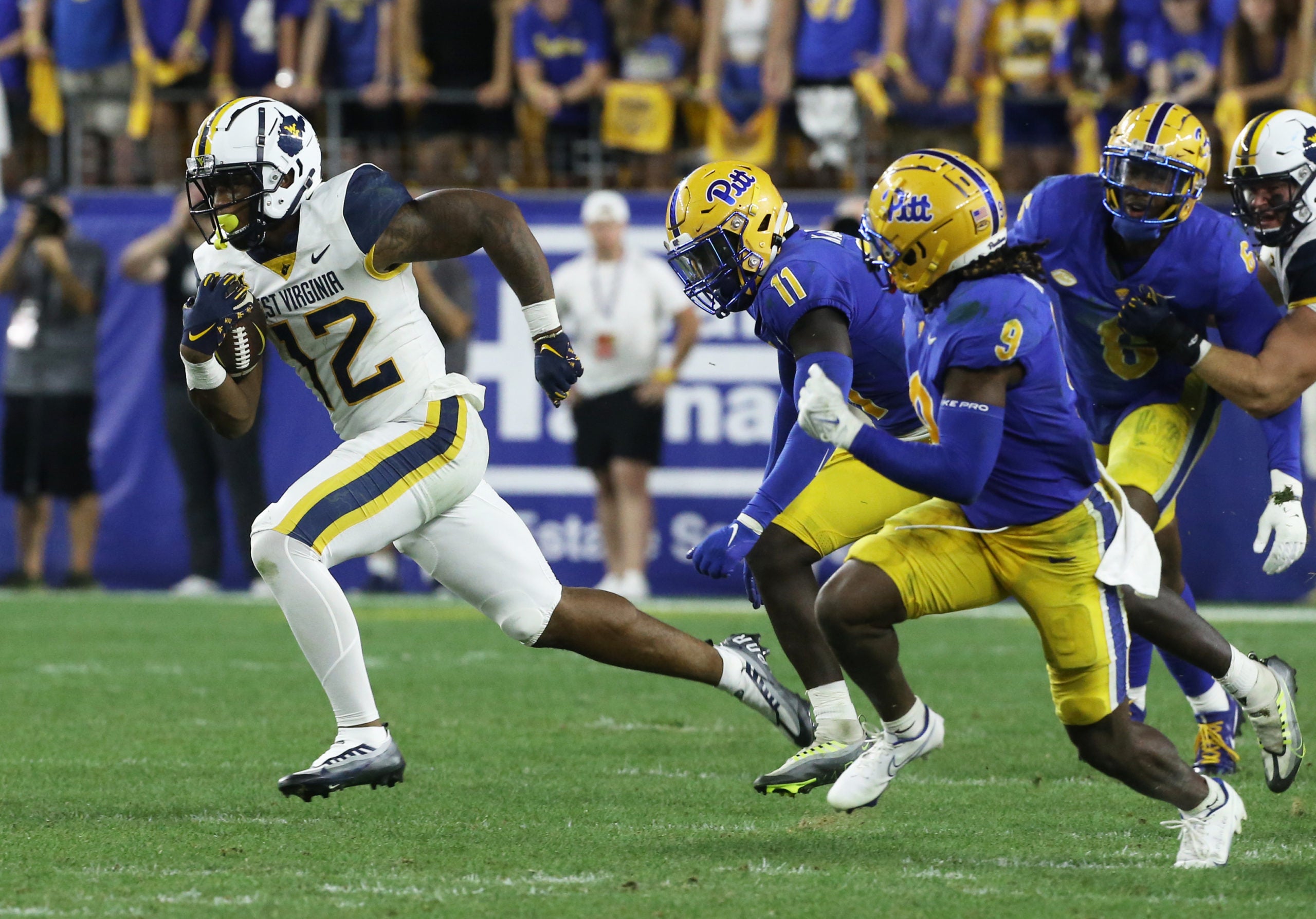 Sep 1, 2022; Pittsburgh, Pennsylvania, USA; West Virginia Mountaineers tight end CJ Donaldson (12) runs after a catch against Pittsburgh Panthers linebacker Bangally Kamara (11) and defensive back Brandon Hill (9) during the fourth quarter at Acrisure Stadium. Pittsburgh won 38-31. Mandatory Credit: Charles LeClaire-USA TODAY Sports