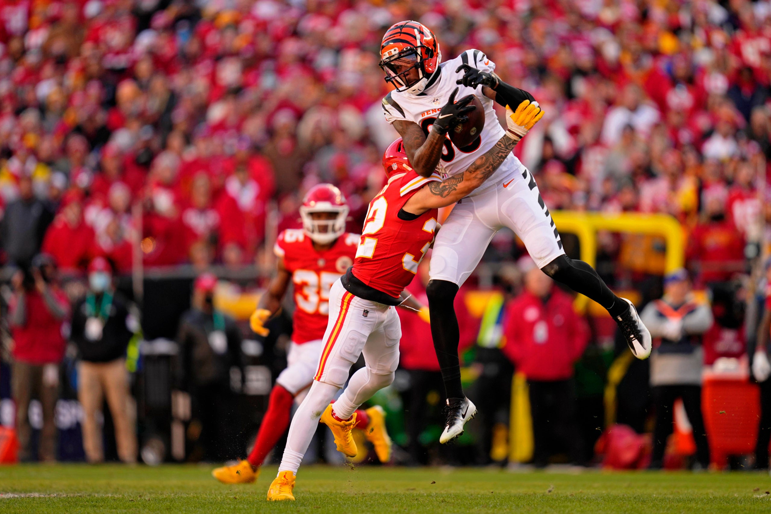 Jan 30, 2022; Kansas City, Missouri, USA; Cincinnati Bengals wide receiver Tee Higgins (85) reaches for a pass while defended by Kansas City Chiefs free safety Tyrann Mathieu (32) during the second quarter of the AFC Championship Game at GEHA Field at Arrowhead Stadium. Mandatory Credit: Jay Biggerstaff-USA TODAY Sports