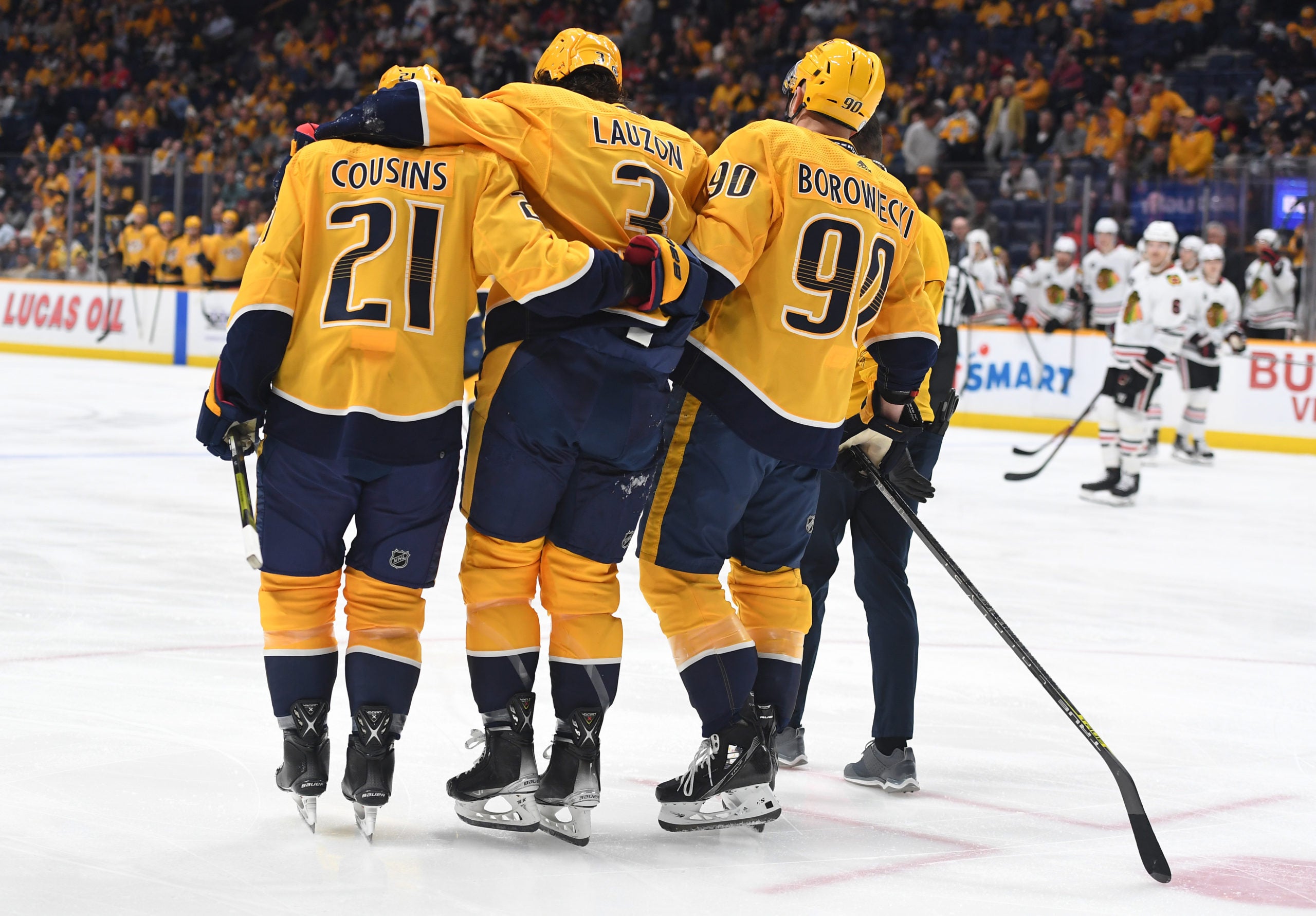 Mark Borowiecki helps Jeremy Lauzon off the ice at a Predators home game