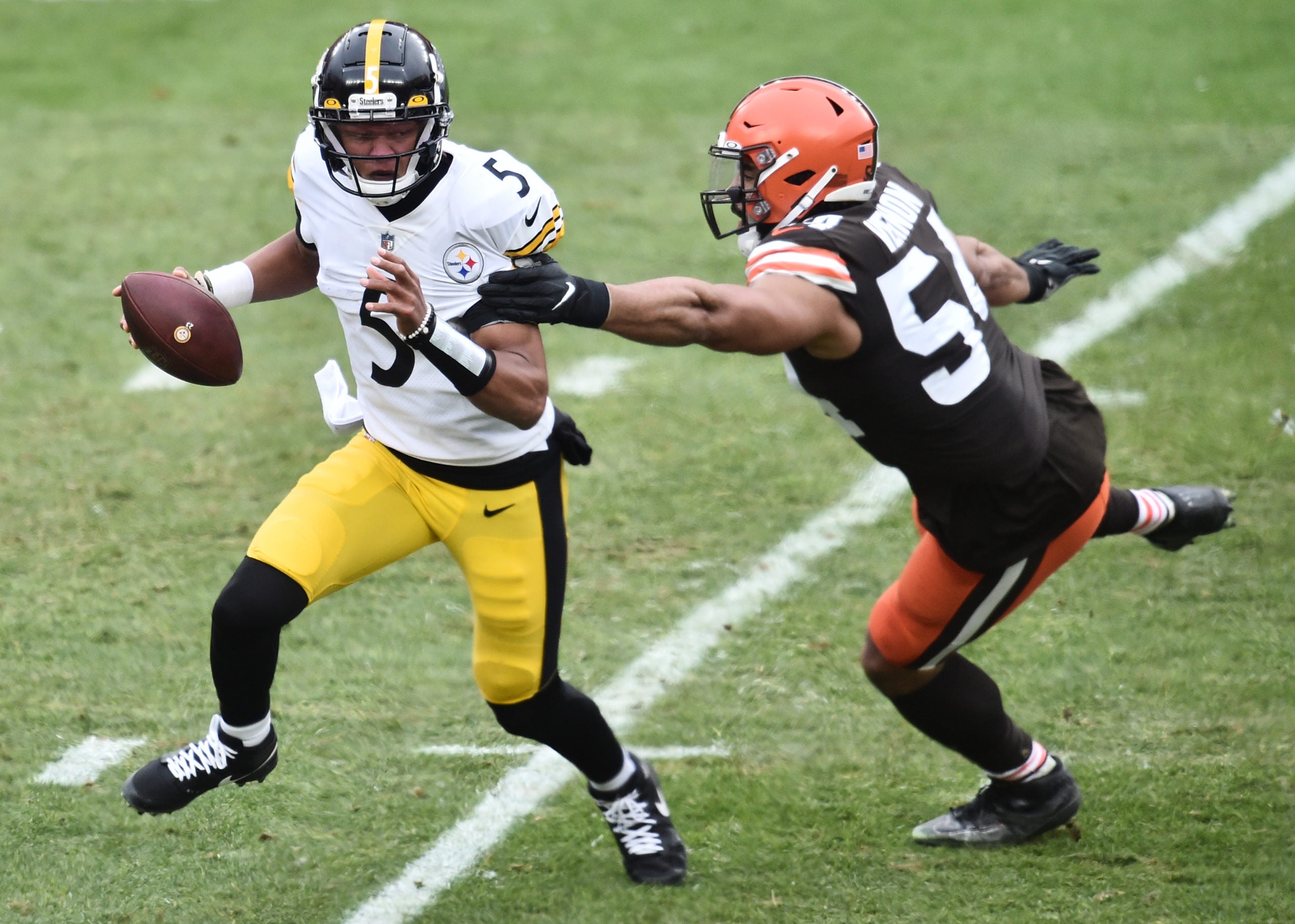 Jan 3, 2021; Cleveland, Ohio, USA; Pittsburgh Steelers quarterback Joshua Dobbs (5) is chased by Cleveland Browns defensive end Olivier Vernon (54) during the second half at FirstEnergy Stadium. Mandatory Credit: Ken Blaze-USA TODAY Sports