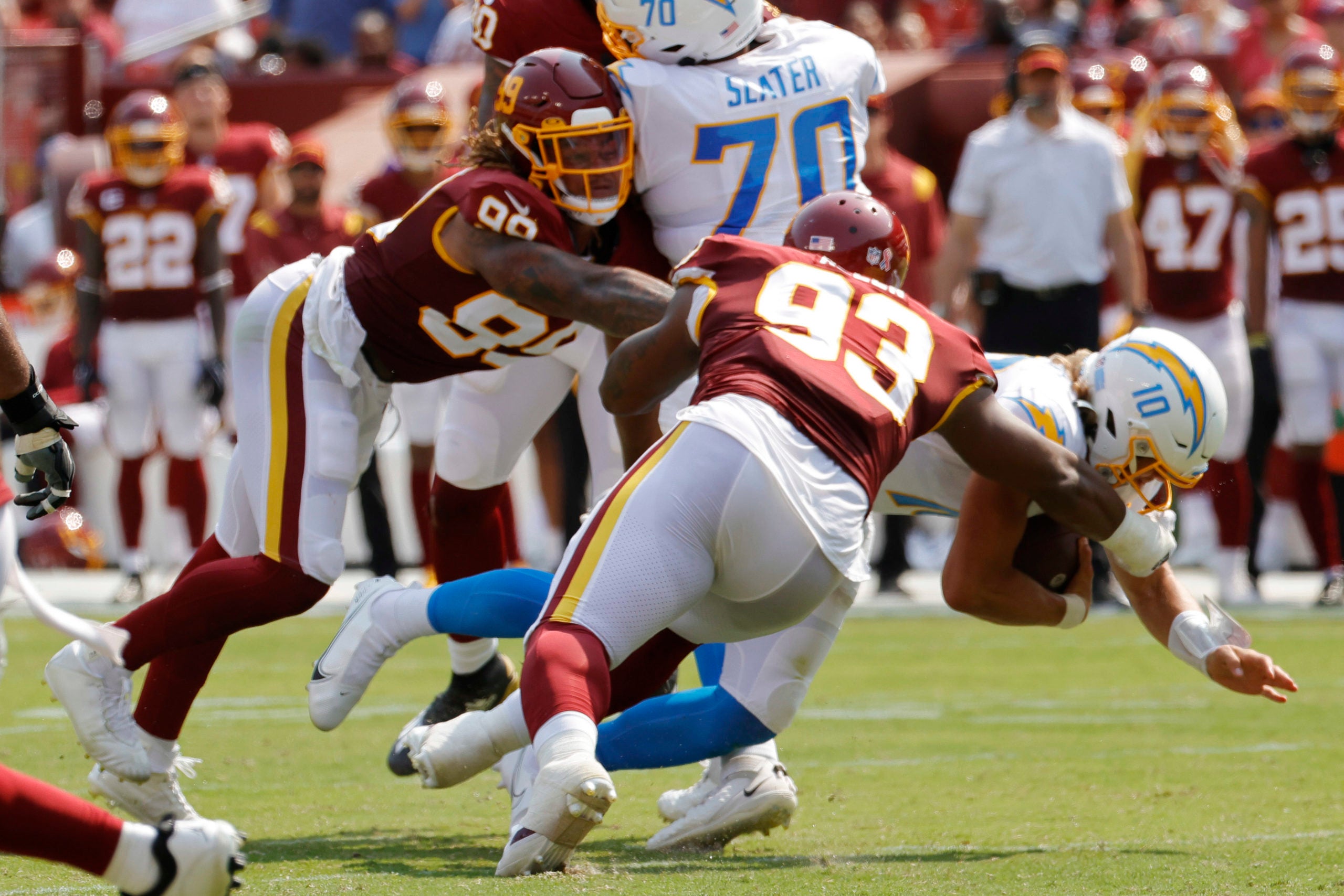 Sep 12, 2021; Landover, Maryland, USA; Los Angeles Chargers quarterback Justin Herbert (10) is sacked by Washington Football Team defensive tackle Jonathan Allen (93) and Washington Football Team defensive end Chase Young (99) in the second quarter at FedExField. Mandatory Credit: Geoff Burke-USA TODAY Sports