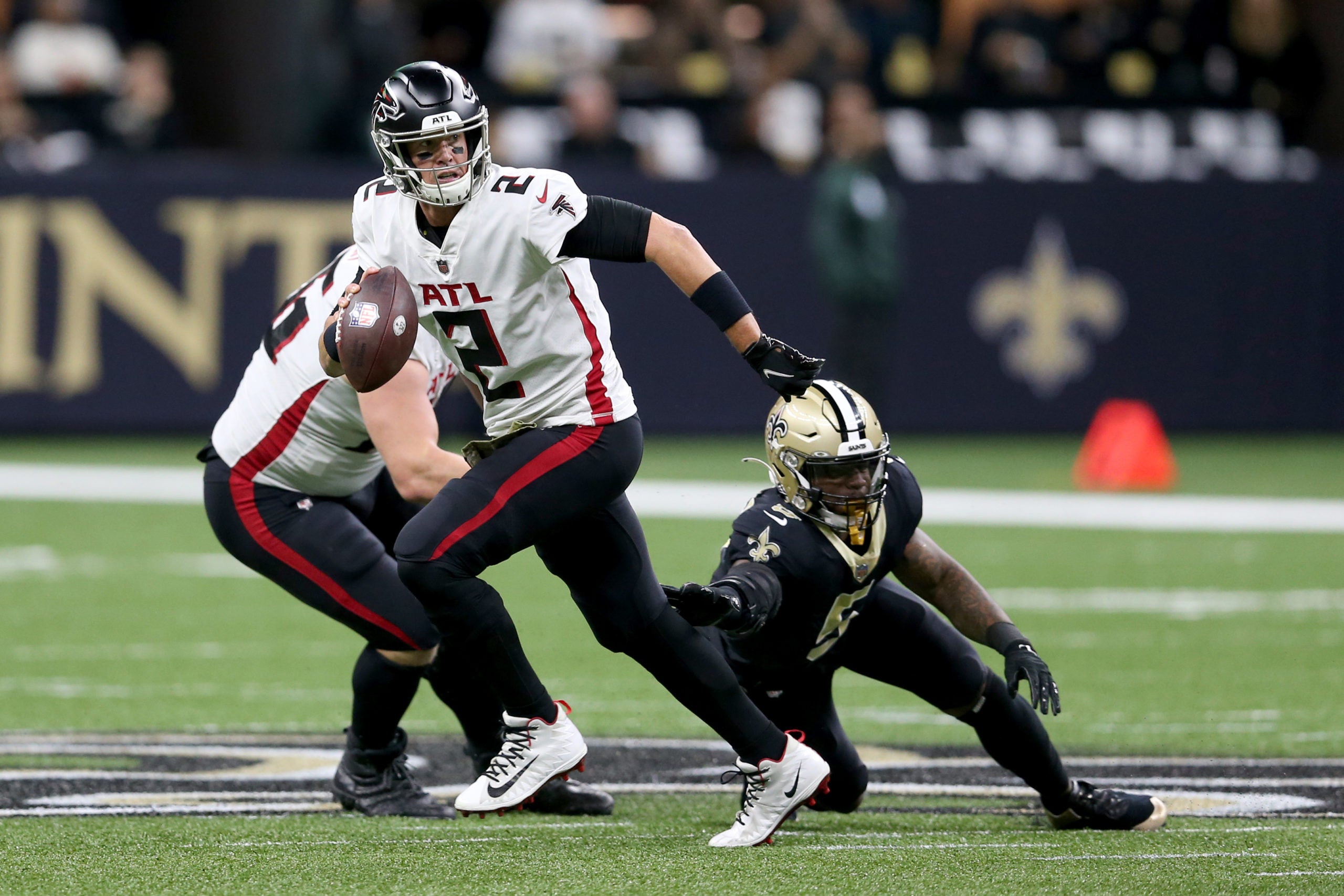Nov 7, 2021; New Orleans, Louisiana, USA; Atlanta Falcons quarterback Matt Ryan (2) escapes the rush by New Orleans Saints middle linebacker Kwon Alexander (5) during the first quarter at the Caesars Superdome. Mandatory Credit: Chuck Cook-USA TODAY Sports