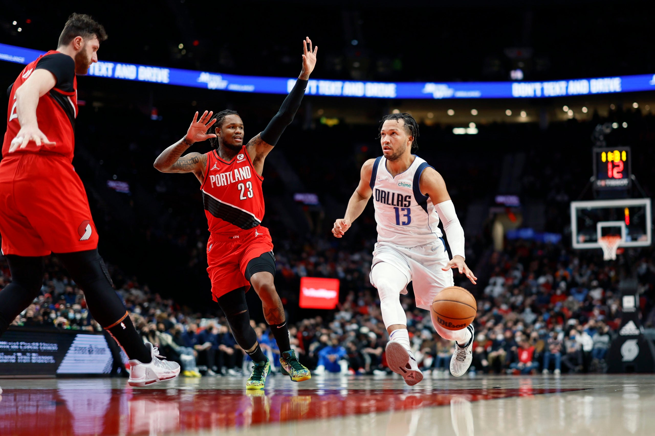 Jan 26, 2022; Portland, Oregon, USA; Dallas Mavericks point guard Jalen Brunson (13) drives to the basket past Portland Trail Blazers shooting guard Ben McLemore (23) during the second half at Moda Center. Mandatory Credit: Soobum Im-USA TODAY Sports