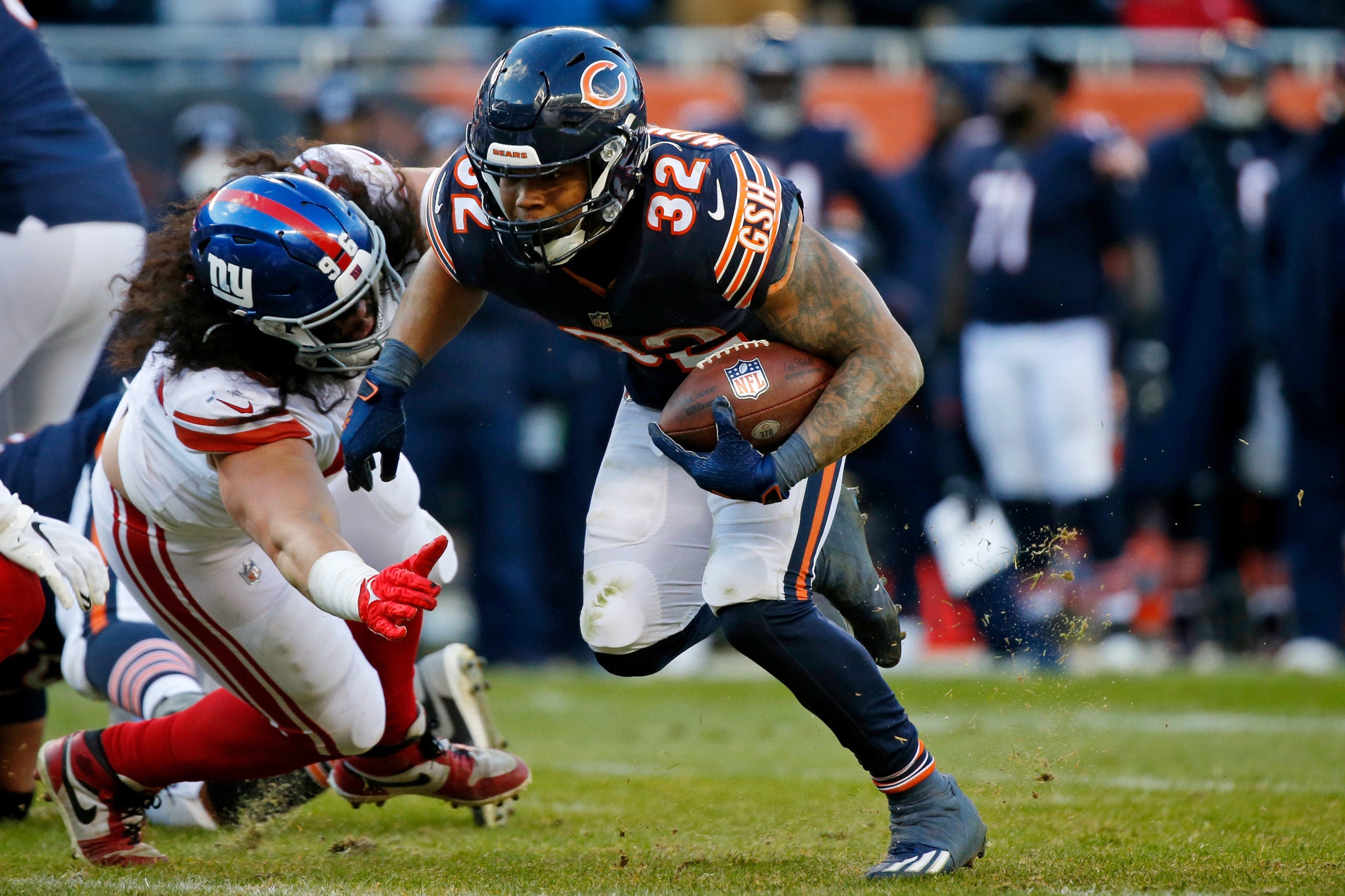 Jan 2, 2022; Chicago, Illinois, USA; Chicago Bears running back David Montgomery (32) runs with the ball as he evades the tackle of New York Giants defensive tackle David Moa (96) during the second half at Soldier Field. Mandatory Credit: Jon Durr-USA TODAY Sports