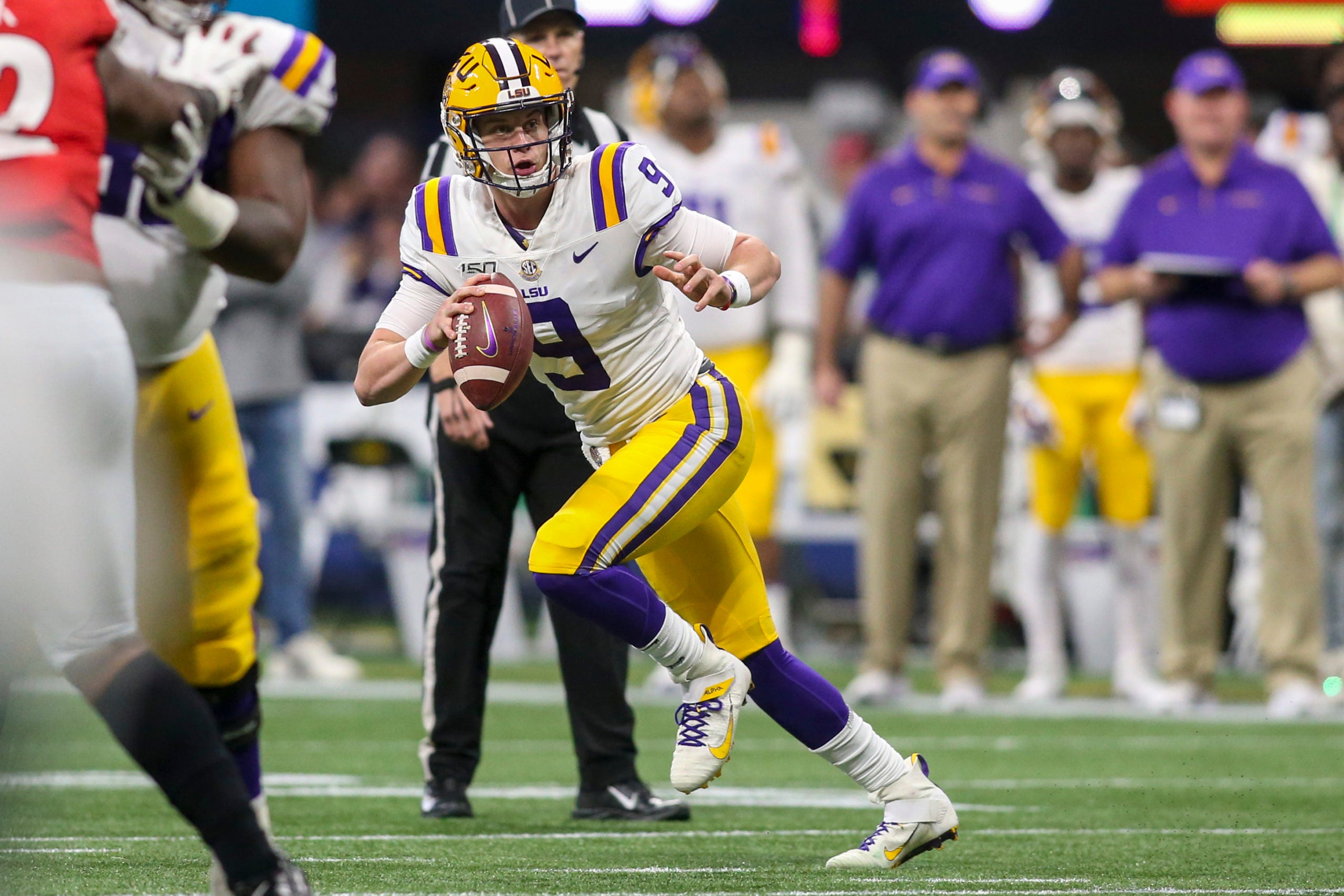 Dec 7, 2019; Atlanta, GA, USA; LSU Tigers quarterback Joe Burrow (9) scrambles against the Georgia Bulldogs in the first quarter in the 2019 SEC Championship Game at Mercedes-Benz Stadium. Mandatory Credit: Brett Davis-USA TODAY Sports