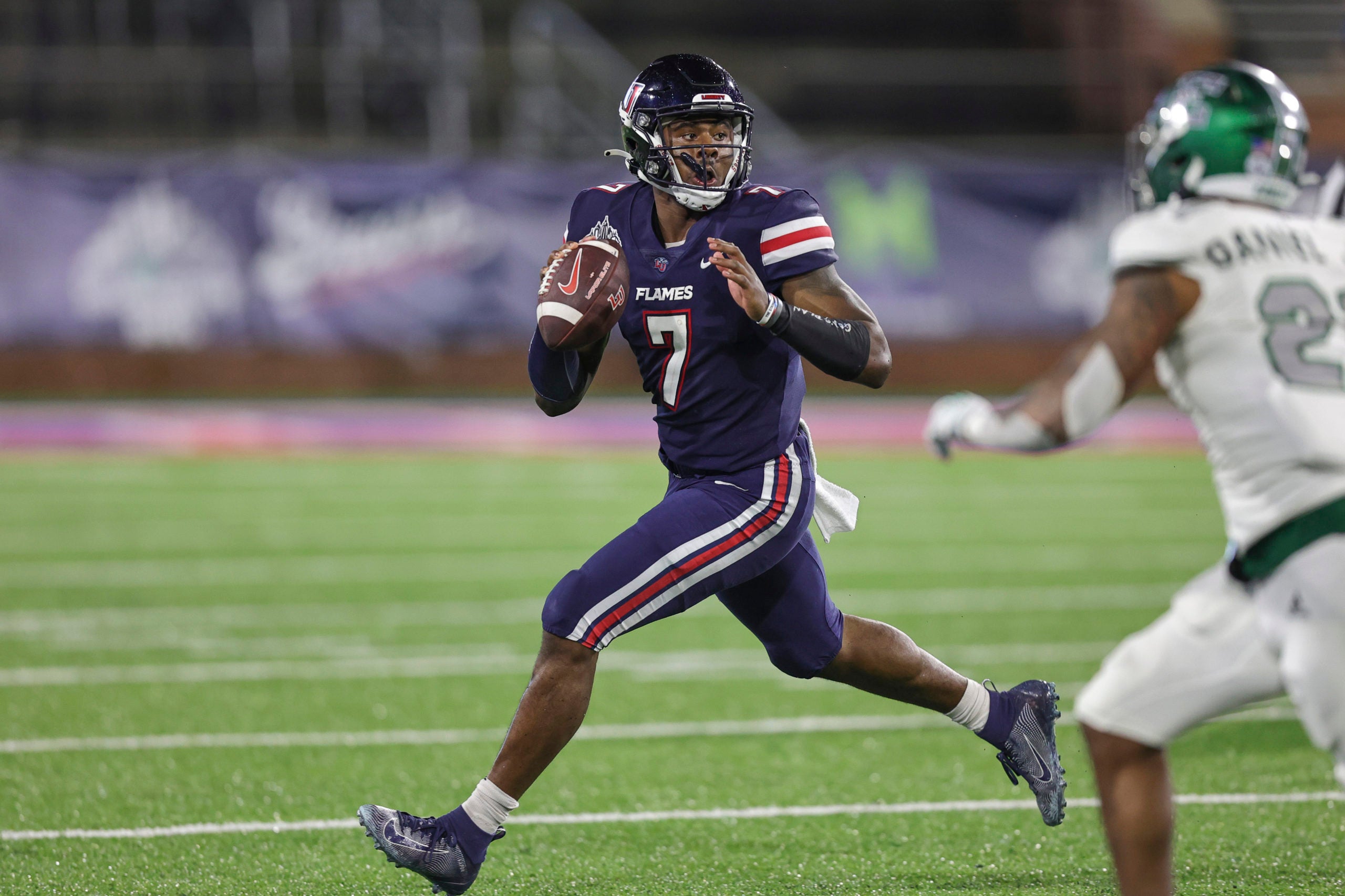 Dec 18, 2021; Mobile, Alabama, USA; Liberty Flames quarterback Malik Willis (7) rolls out to pass against the Eastern Michigan Eagles in the third quarter during the 2021 LendingTree Bowl at Hancock Whitney Stadium. Mandatory Credit: Robert McDuffie-USA TODAY Sports