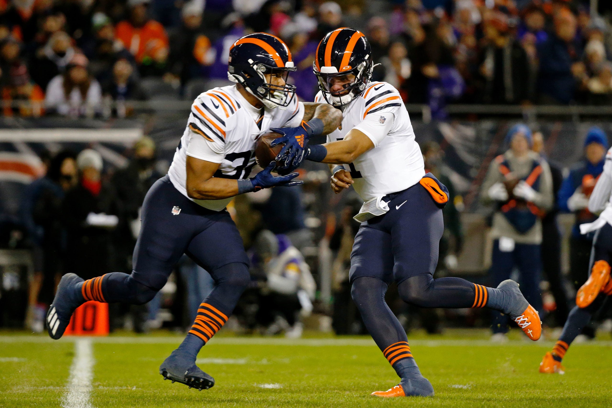 Dec 20, 2021; Chicago, Illinois, USA; Chicago Bears quarterback Justin Fields (1) hands the ball off to running back David Montgomery (32) against the Minnesota Vikings during the first quarter at Soldier Field. Mandatory Credit: Jon Durr-USA TODAY Sports