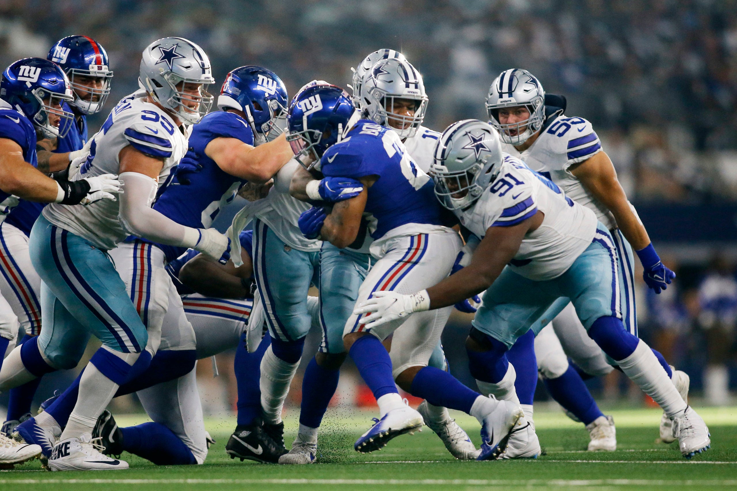 Oct 10, 2021; Arlington, Texas, USA; New York Giants running back Devontae Booker (28) is tackled by Dallas Cowboys defensive tackle Carlos Watkins (91) in the third quarter at AT&T Stadium. Mandatory Credit: Tim Heitman-USA TODAY Sports