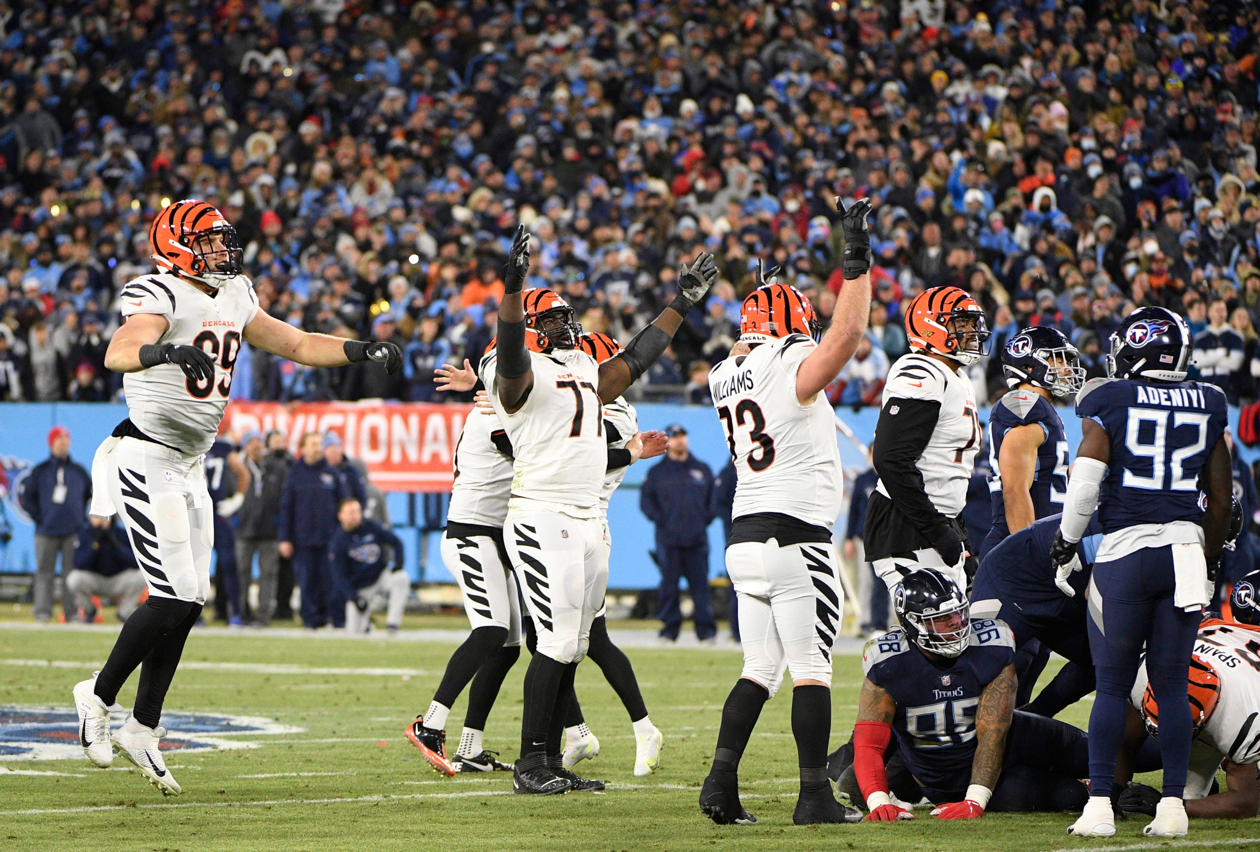 Jan 22, 2022; Nashville, Tennessee, USA; Cincinnati Bengals tight end Drew Sample (89), guard Hakeem Adeniji (77) and offensive tackle Jonah Williams (73) celebrate kicker Evan McPherson (2) making a game-winning 52-yard field goal in the fourth quarter off the AFC Divisional playoff football game against the Tennessee Titans at Nissan Stadium. The Bengals won the game 19-16. Mandatory Credit: Steve Roberts-USA TODAY Sports