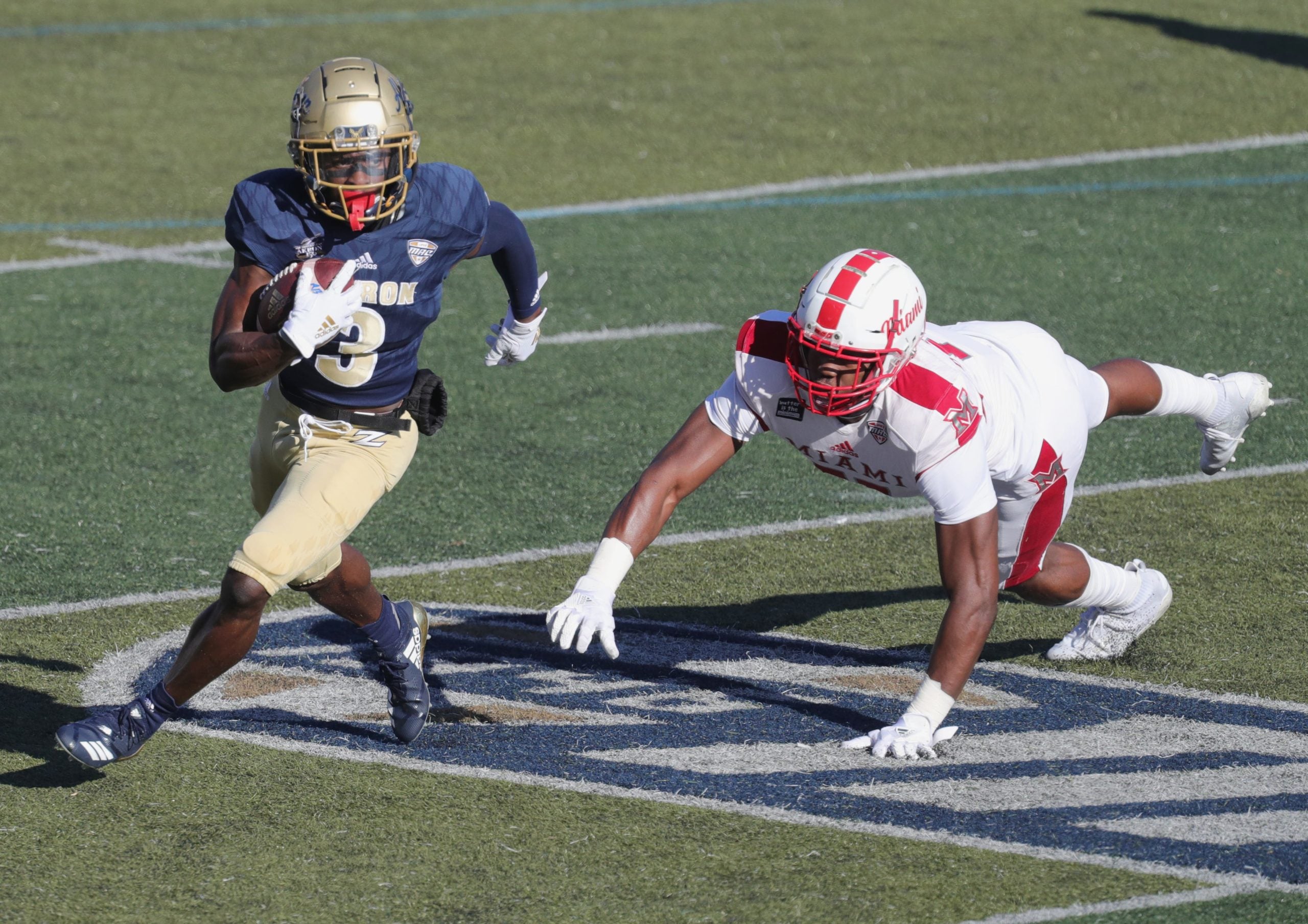University of Akron's Michael Mathison gets past Miami RedhawksÕ Dominique Robinson after a first quarter pass on Saturday, Nov. 28, 2020 in Akron, Ohio, at InfoCision Stadium. [Phil Masturzo/ Beacon Journal] Zips Miami3