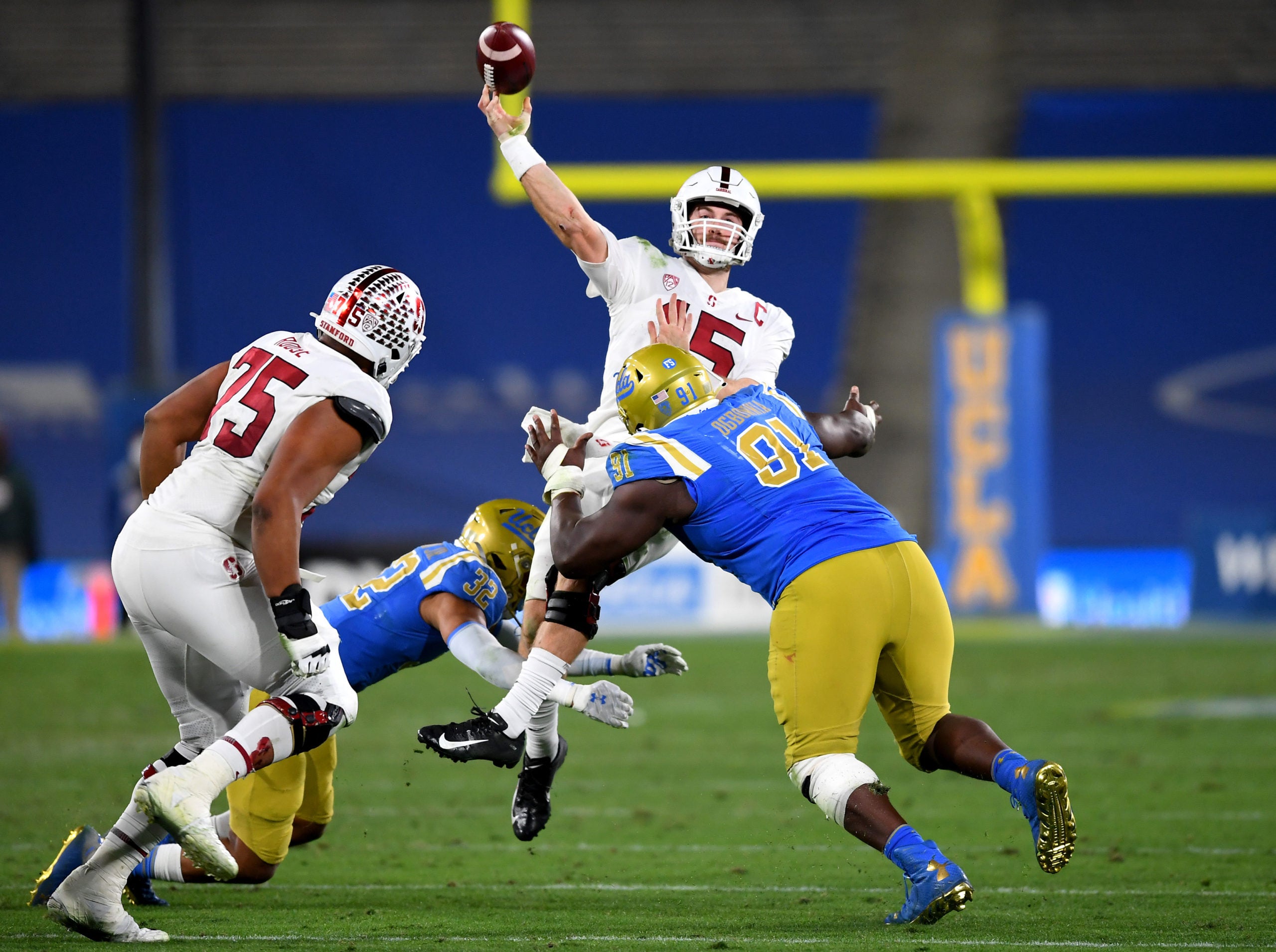 Dec 19, 2020; Pasadena, California, USA; UCLA Bruins defensive lineman Otito Ogbonnia (91) pressures Stanford Cardinal quarterback Davis Mills (15) as he scrambles to throw a pass during overtime against the UCLA Bruins at the Rose Bowl. Mandatory Credit: Jayne Kamin-Oncea-USA TODAY Sports