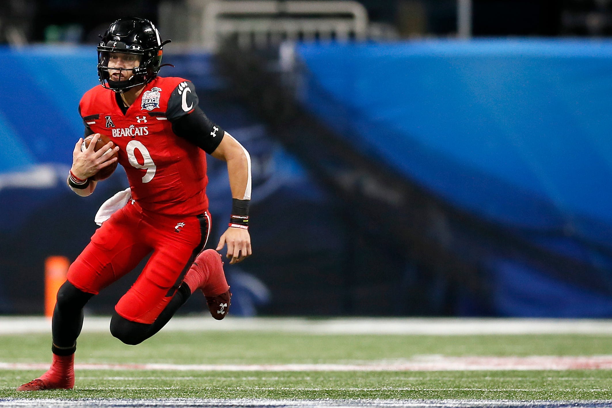 Cincinnati Bearcats quarterback Desmond Ridder (9) runs the ball on a keeper in the second quarter of the Chick-fil-a Peach Bowl at Mercedes-Benz Stadium in Atlanta on Friday, Jan. 1, 2021. The Bearcats led 14-10 at halftime. Cincinnati Bearcats Vs Georgia Bulldogs Peach Bowl