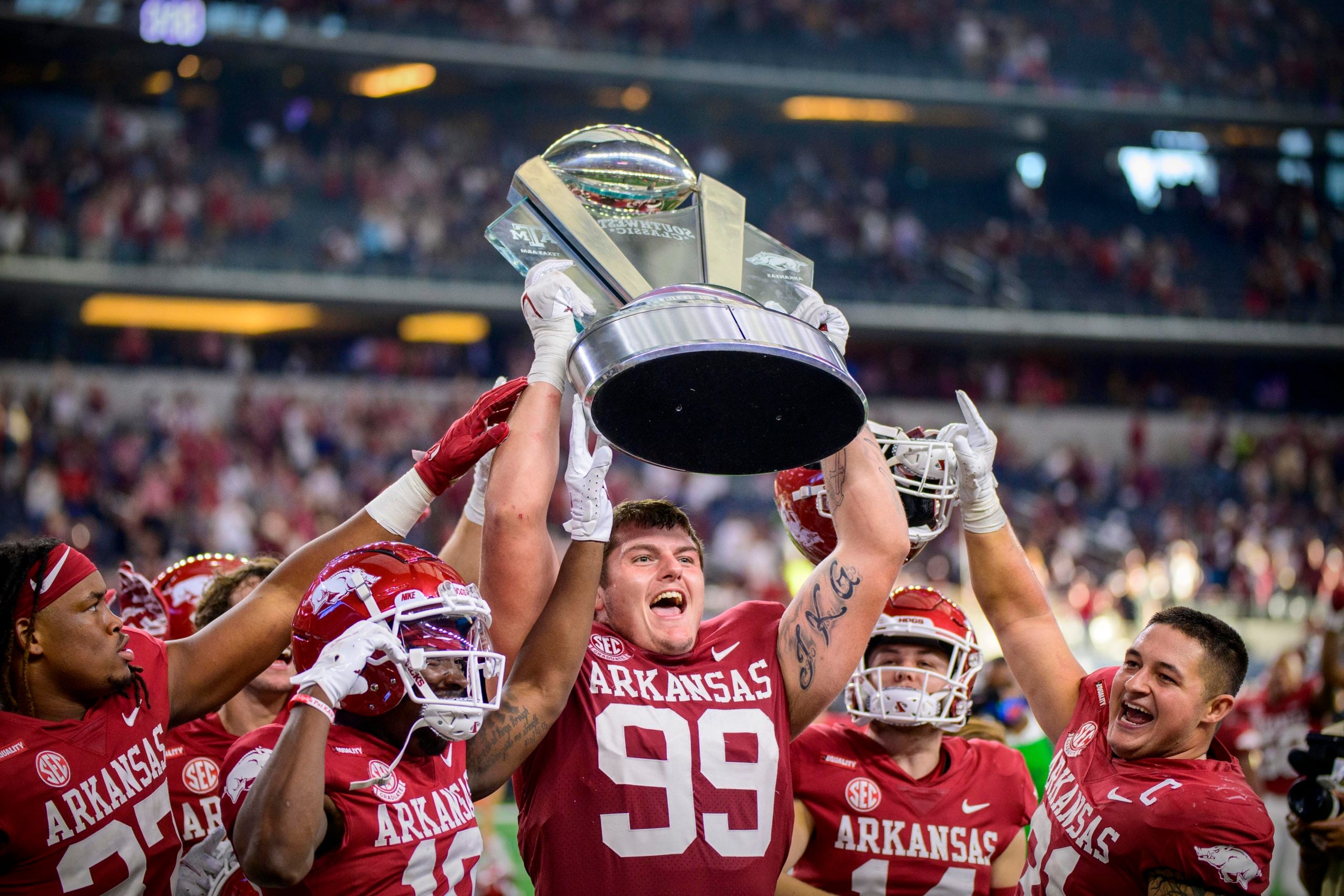 Sep 25, 2021; Arlington, Texas, USA;  Arkansas Razorbacks defensive lineman Eric Thomas Jr. (37) and defensive lineman John Ridgeway (99) and linebacker Grant Morgan (31) hold up the Southwest Classic trophy as they celebrate the win over the Texas A&M Aggies at AT&T Stadium. Mandatory Credit: Jerome Miron-USA TODAY Sports