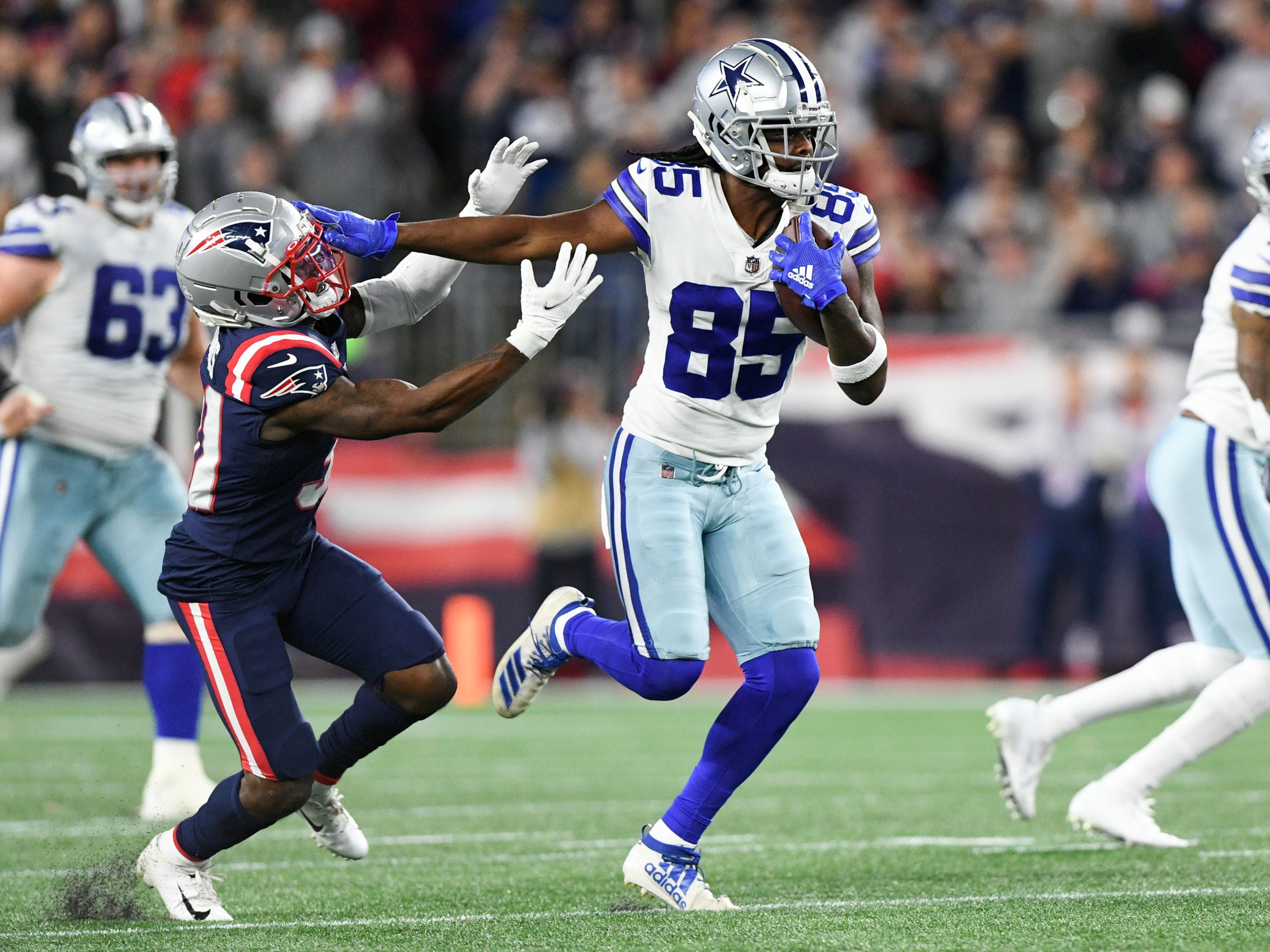 Oct 17, 2021; Foxborough, Massachusetts, USA; Dallas Cowboys wide receiver Noah Brown (85) runs with the ball and stiff-arms New England Patriots defensive back Jonathan Jones (31) during the second half at Gillette Stadium. Mandatory Credit: Brian Fluharty-USA TODAY Sports