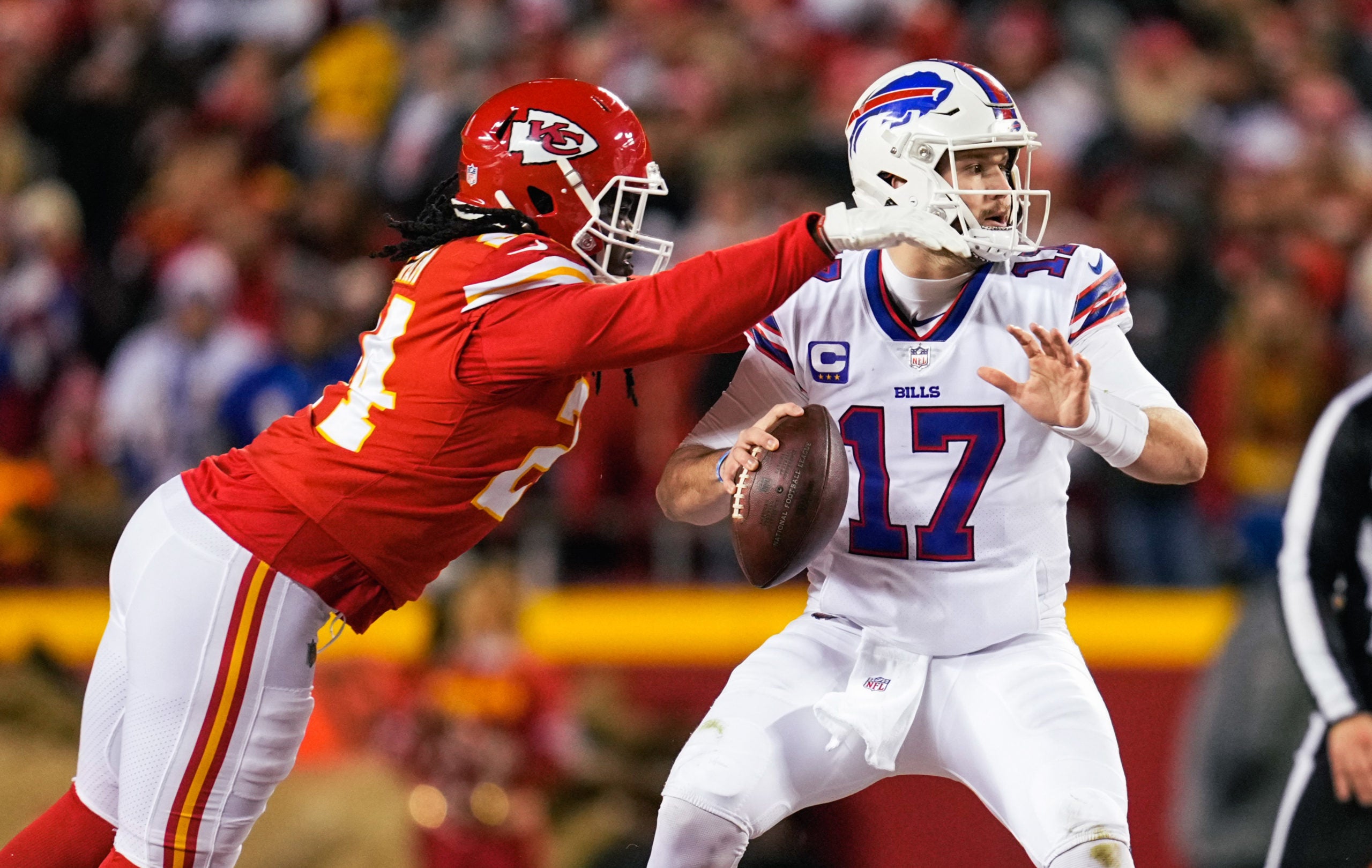 Jan 23, 2022; Kansas City, Missouri, USA; Buffalo Bills quarterback Josh Allen (17) drops back to pass as Kansas City Chiefs defensive end Melvin Ingram (24) during the first half in a AFC Divisional playoff football game at GEHA Field at Arrowhead Stadium. Mandatory Credit: Jay Biggerstaff-USA TODAY Sports