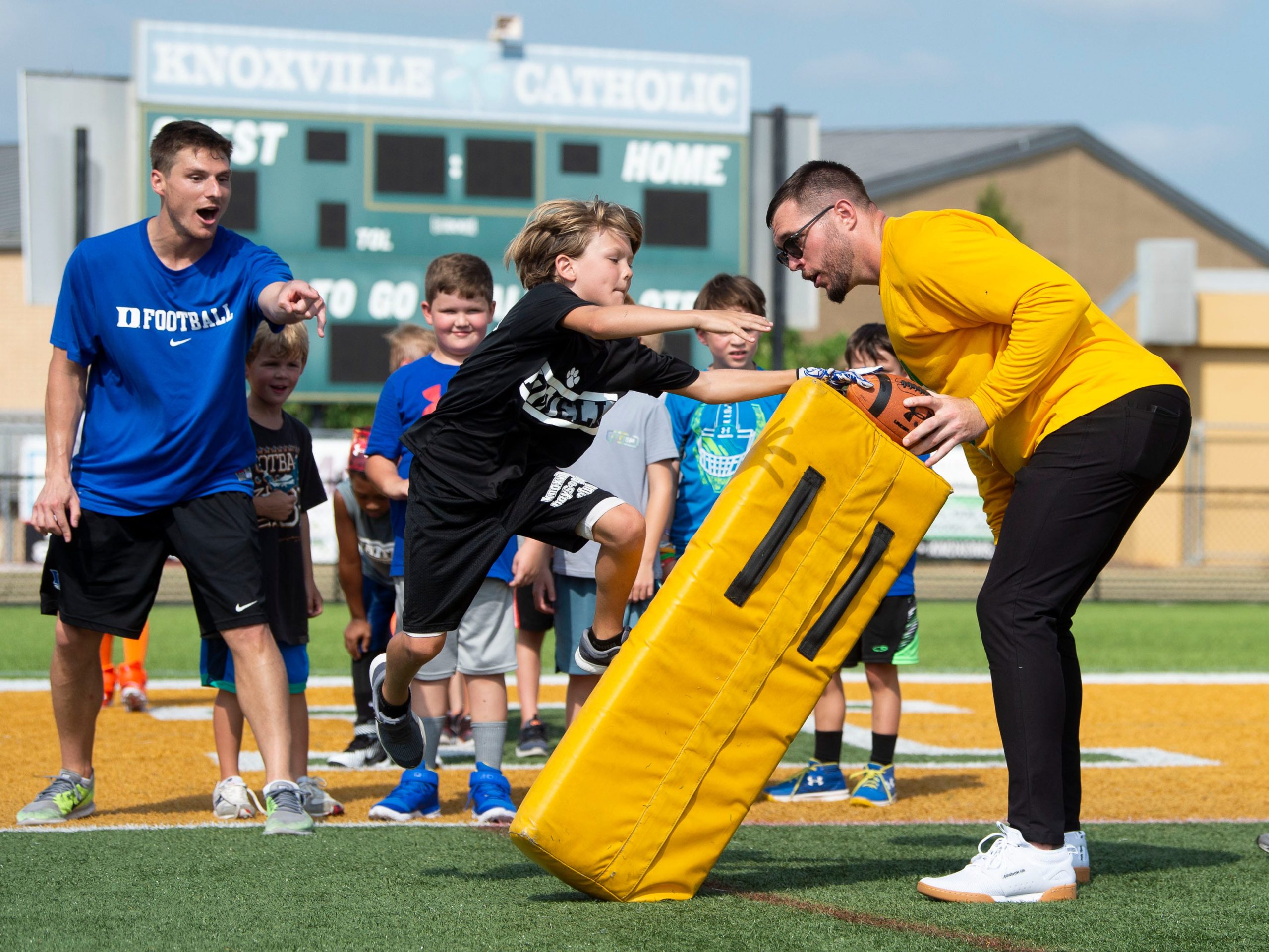 Harrison Smith, Knoxville Catholic alumnus and Minnesota Vikings Safety and Duke assistant football coach Jeff Faris working with young football players at the Smith & Smith Catholic Football Camp at Knoxville Catholic on Monday, July 8, 2019. Kns Catholic Football Camp