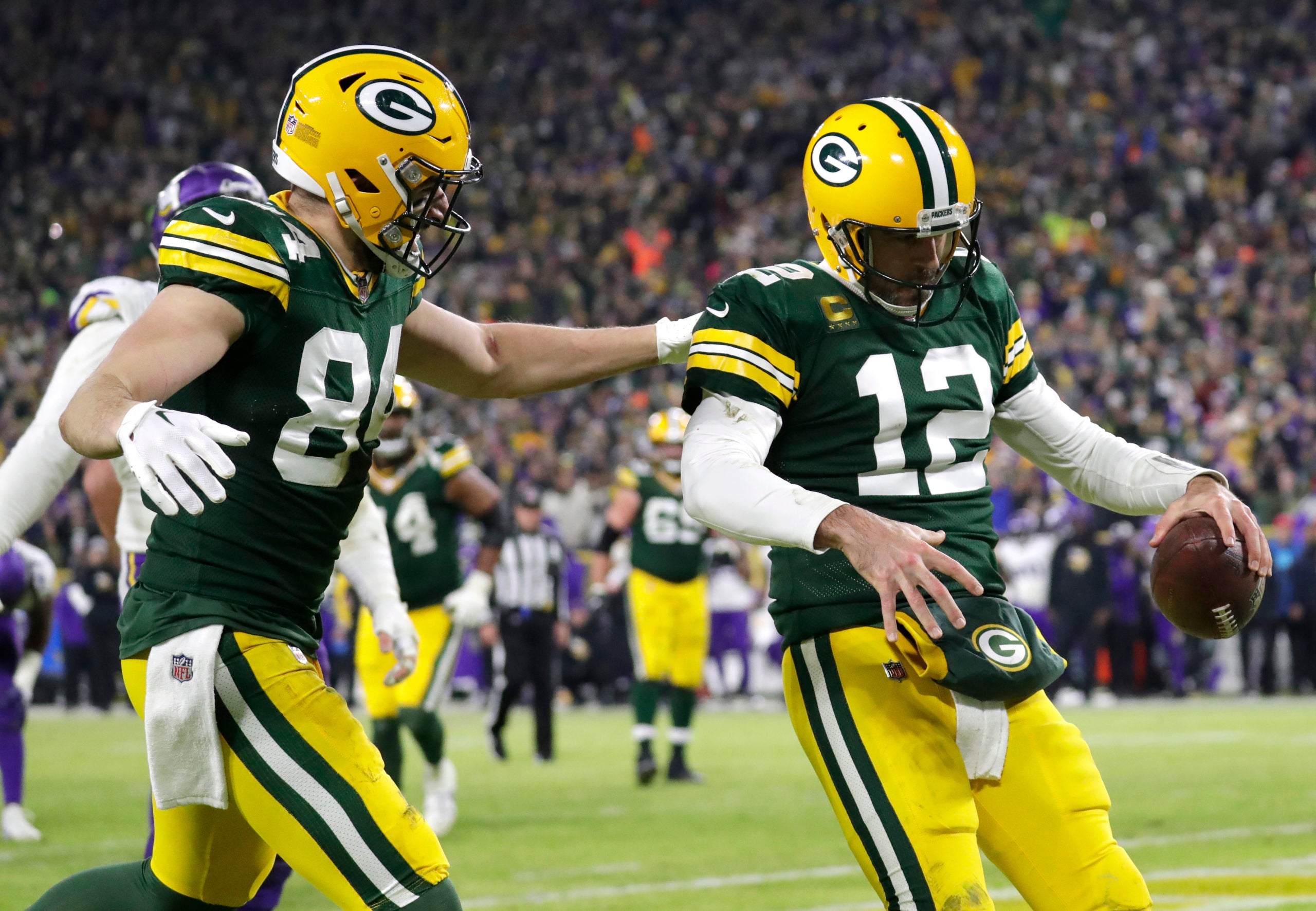 Jan 1, 2023; Green Bay, Wisconsin, USA; Green Bay Packers quarterback Aaron Rodgers (12) celebrates scoring a touchdown with tight end Tyler Davis (84) against the Minnesota Vikings in the fourth quarter of their game at Lambeau Field. Mandatory Credit: Dan Powers-USA TODAY Sports