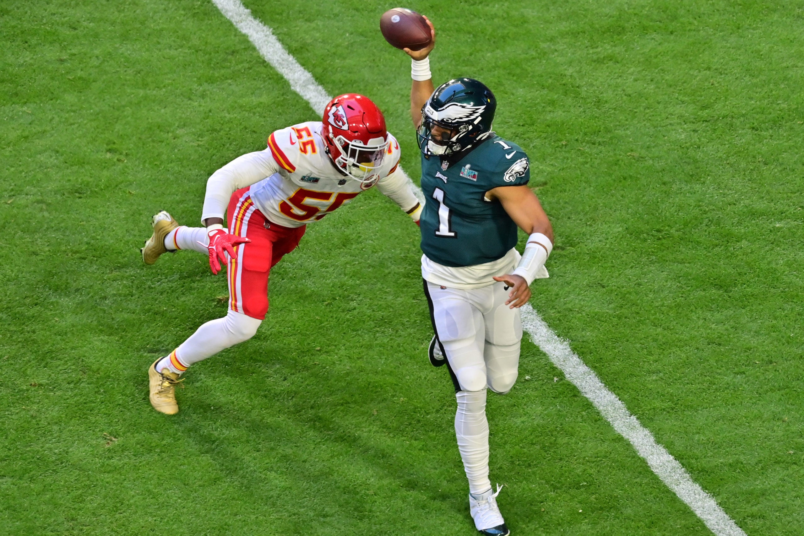 Feb 12, 2023; Glendale, Arizona, US; Philadelphia Eagles quarterback Jalen Hurts (1) rolls out to throw a pass against Kansas City Chiefs defensive end Frank Clark (55) during the first quarter of Super Bowl LVII at State Farm Stadium. Mandatory Credit: Matt Kartozian-USA TODAY Sports