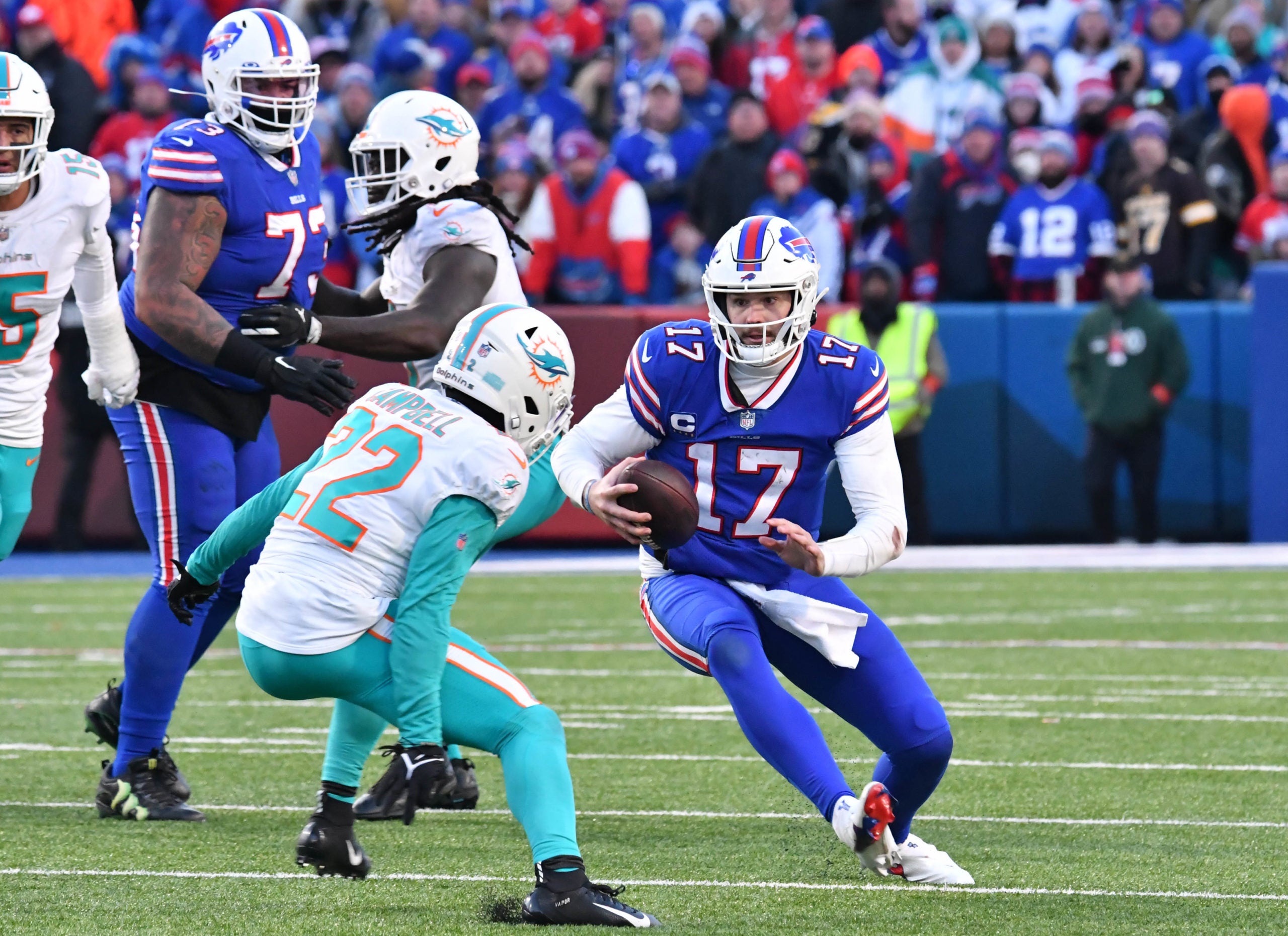 Jan 15, 2023; Orchard Park, NY, USA; Buffalo Bills quarterback Josh Allen (17) runs the ball against Miami Dolphins safety Elijah Campbell (22) during the second half in a NFL wild card game at Highmark Stadium. Mandatory Credit: Mark Konezny-USA TODAY Sports