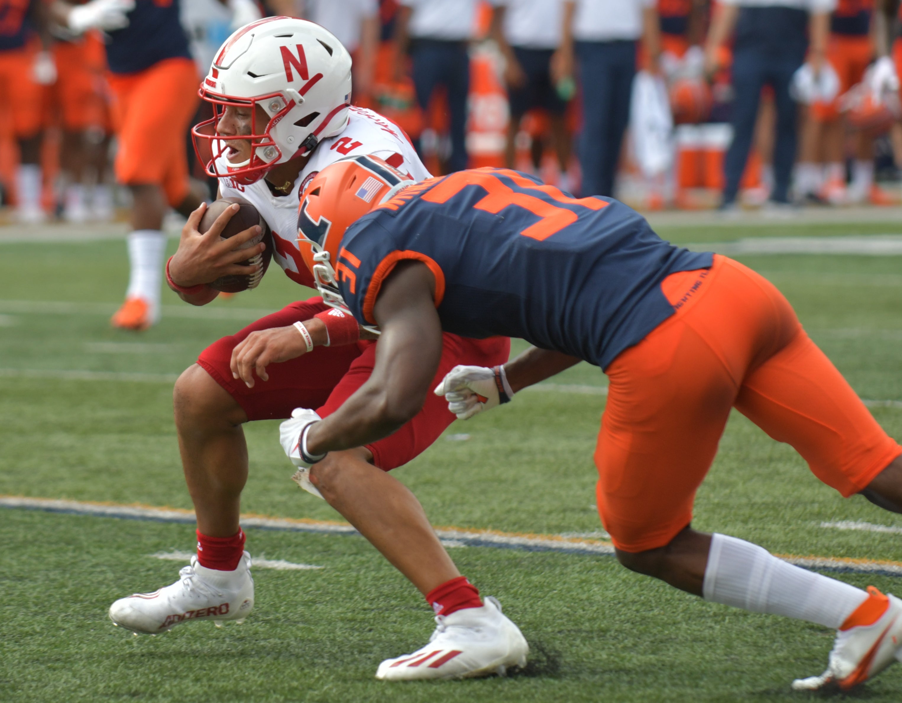 Aug 28, 2021; Champaign, Illinois, USA; Nebraska Cornhuskers quarterback Adrian Martinez (2) is tackled by Illinois Fighting Illini defensive back Devon Witherspoon (31) during the second half at Memorial Stadium.