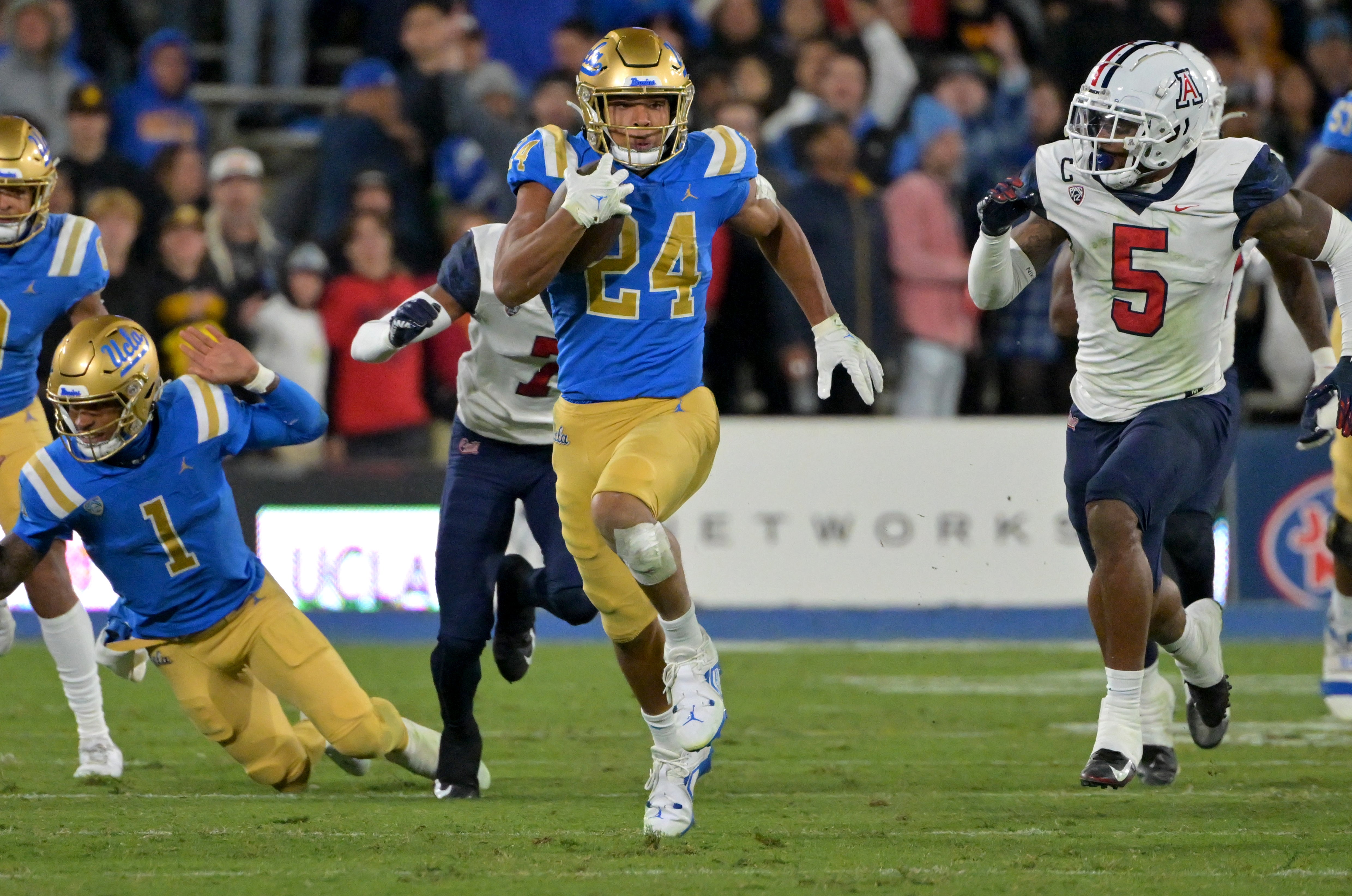 Nov 12, 2022; Pasadena, California, USA; UCLA Bruins running back Zach Charbonnet (24) carries for 37 yards before he is forced out of bounds by Arizona Wildcats safety Christian Young (5) in the first half at the Rose Bow.