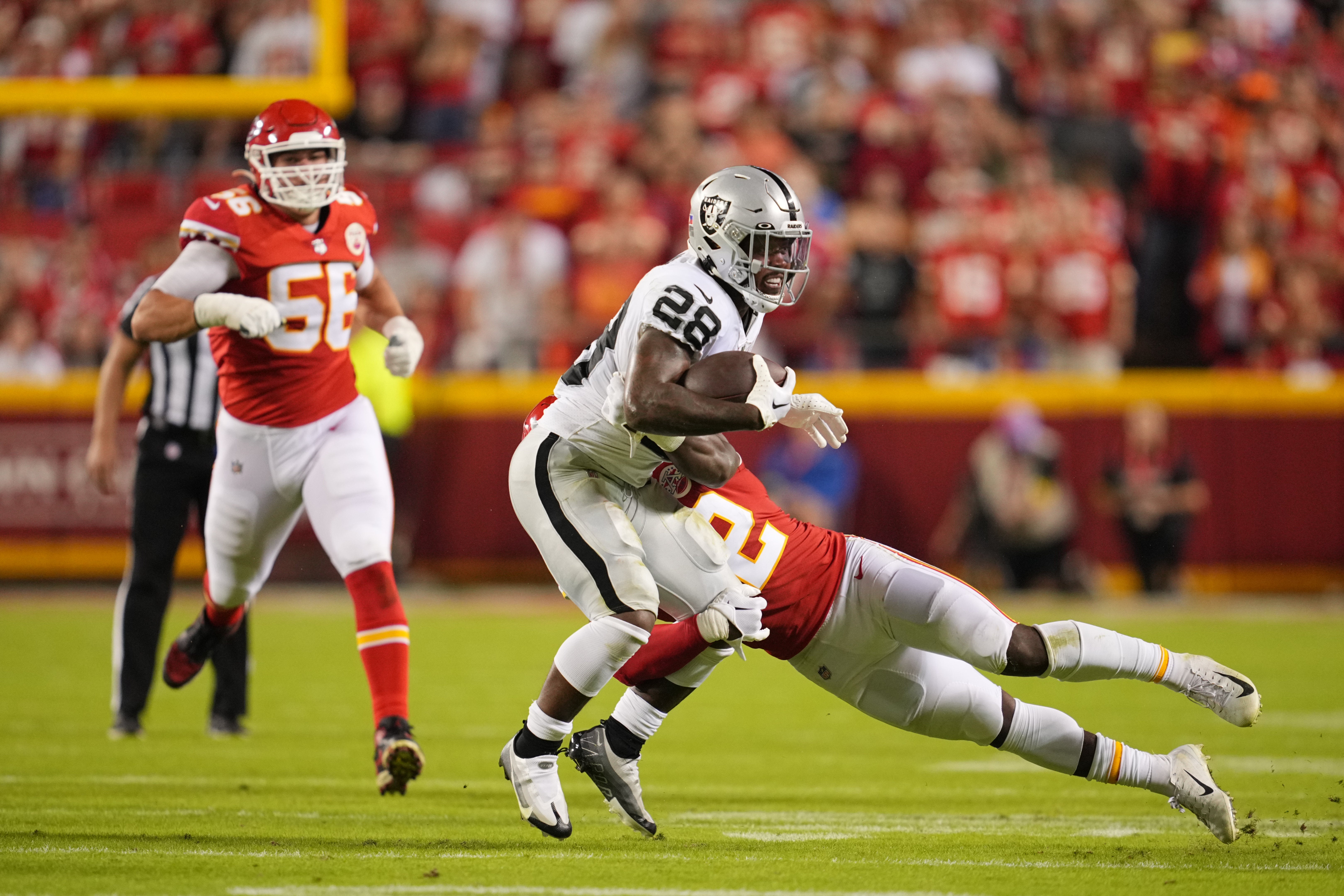 Oct 10, 2022; Kansas City, Missouri, USA; Kansas City Chiefs linebacker Nick Bolton (32) tackles Las Vegas Raiders running back Josh Jacobs (28) in the first half at GEHA Field at Arrowhead Stadium.