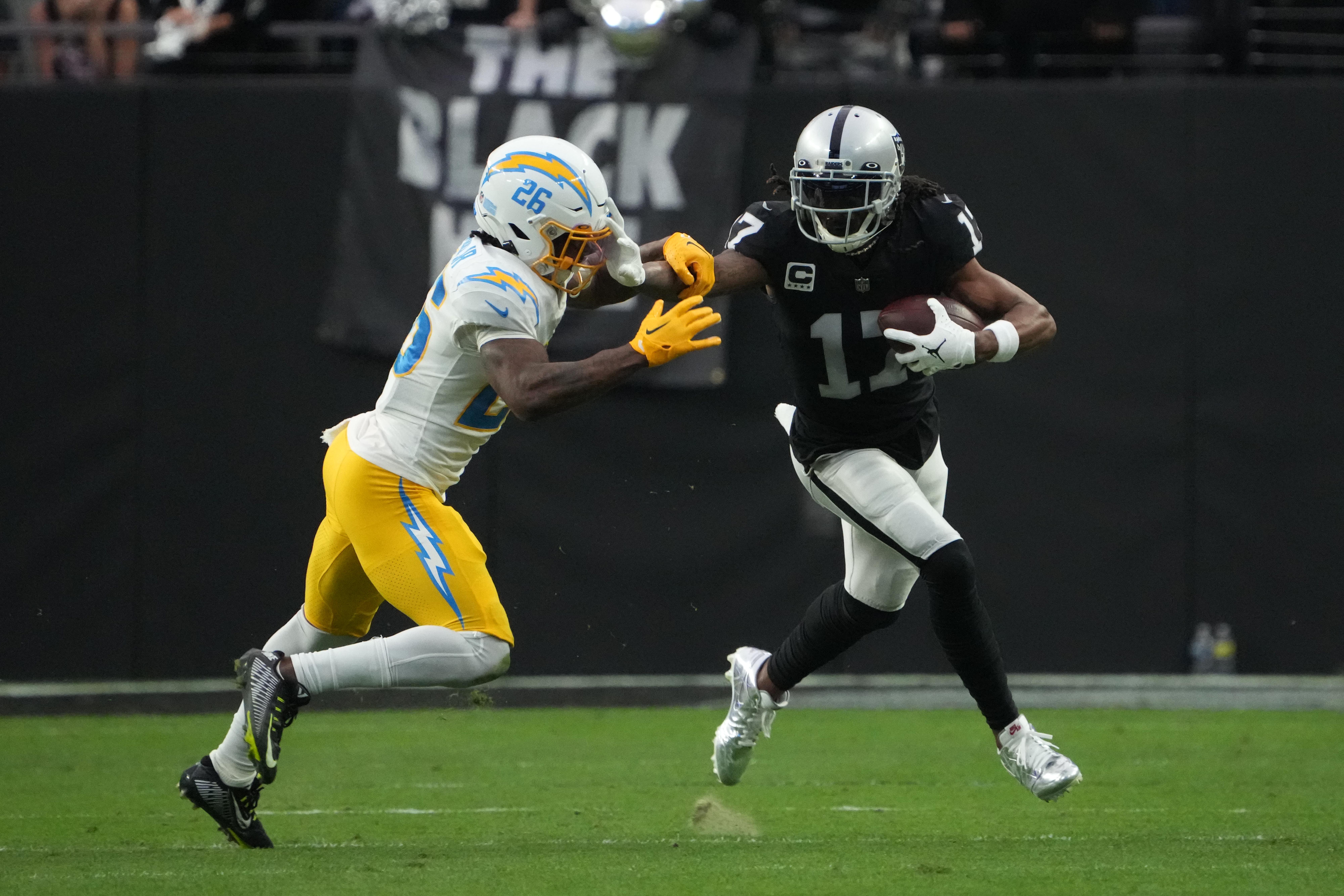 Dec 4, 2022; Paradise, Nevada, USA; Las Vegas Raiders wide receiver Davante Adams (17) carries the ball against Los Angeles Chargers cornerback Asante Samuel Jr. (26) in the first half at Allegiant Stadium.