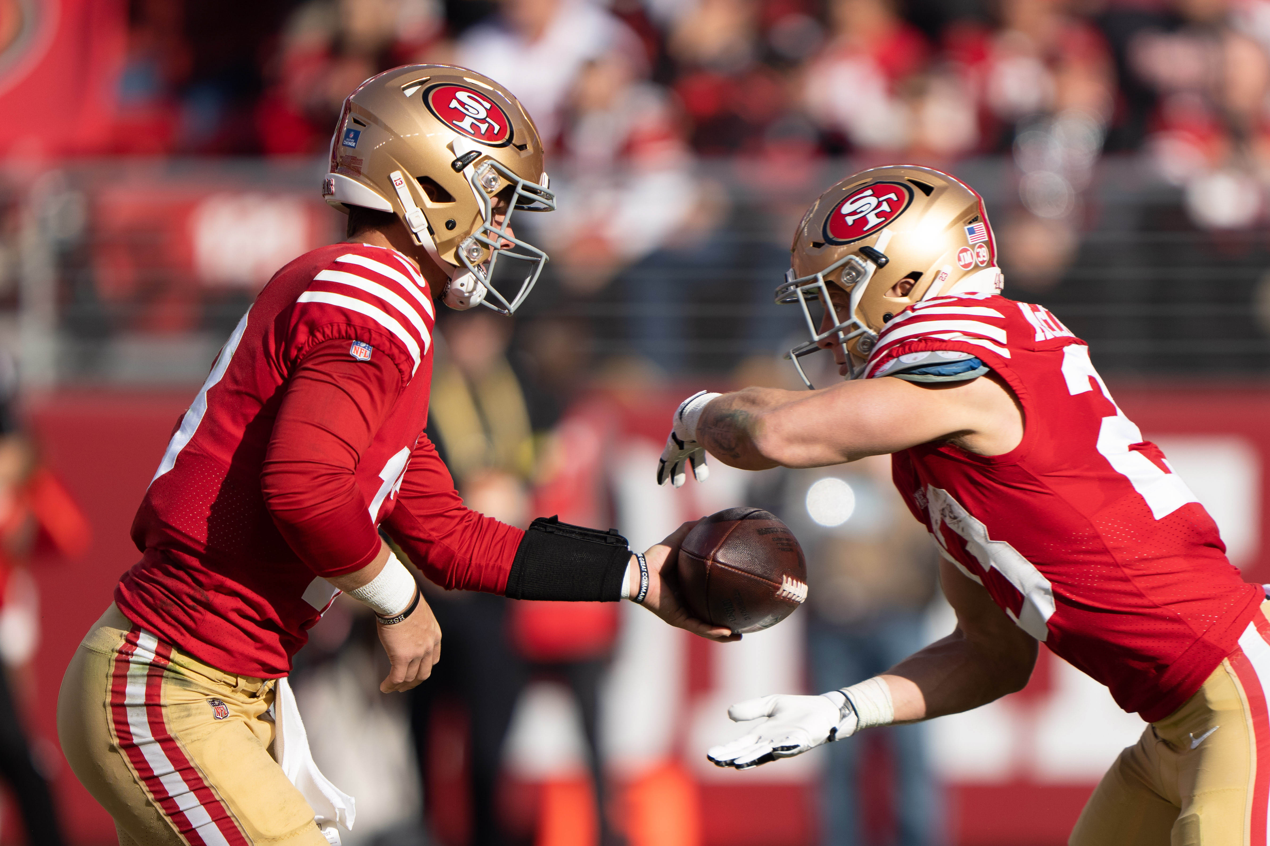 Dec 24, 2022; Santa Clara, California, USA; San Francisco 49ers quarterback Brock Purdy (13) hands the ball off to running back Christian McCaffrey (23) during the second quarter against the Washington Commanders at Levi's Stadium. Mandatory Credit: Stan Szeto-USA TODAY Sports