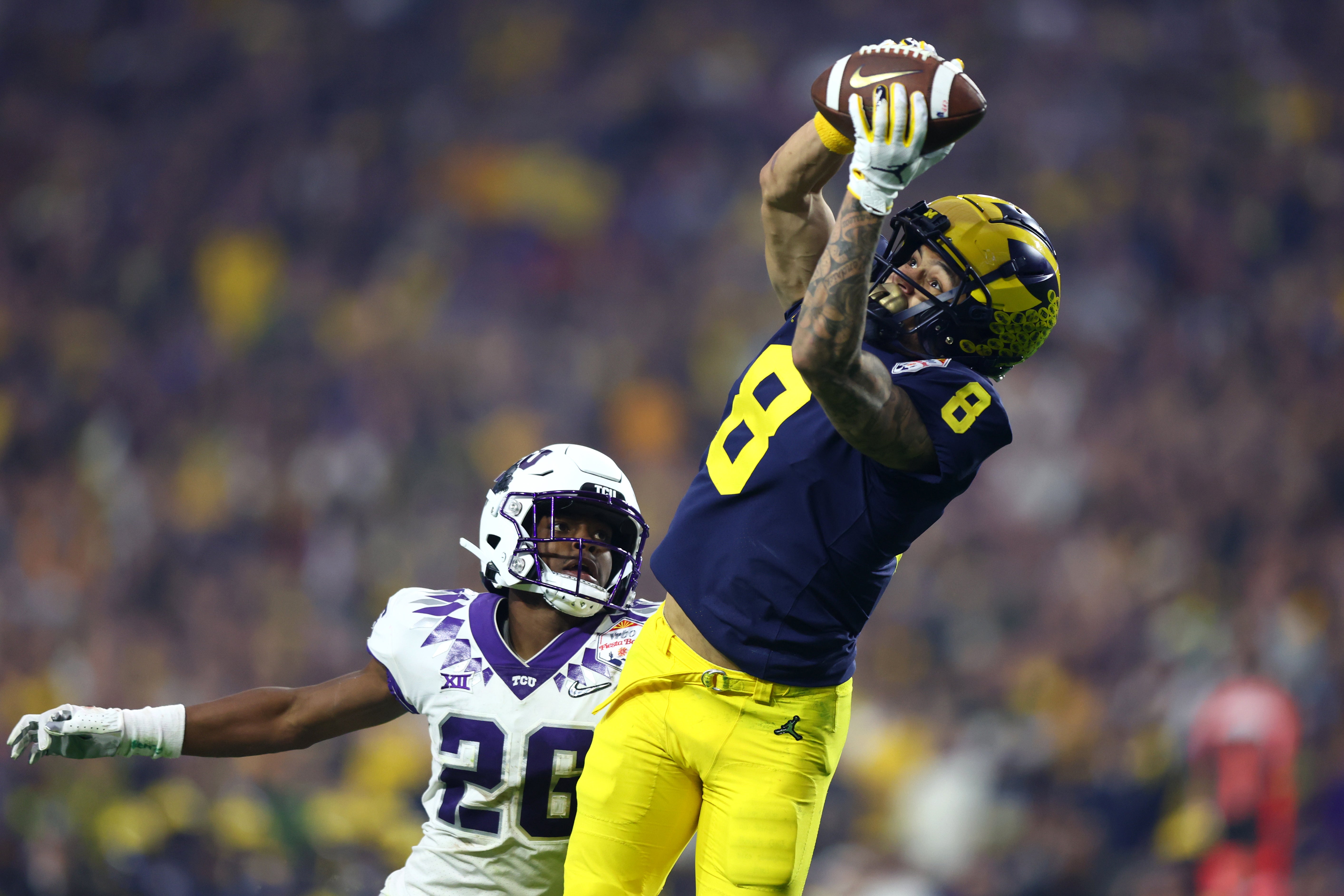 Dec 31, 2022; Glendale, Arizona, USA; Michigan Wolverines wide receiver Ronnie Bell (8) makes a catch against TCU Horned Frogs safety Millard Bradford (28) in the third quarter of the 2022 Fiesta Bowl at State Farm Stadium. Mandatory Credit: Mark J. Rebilas-USA TODAY Sports