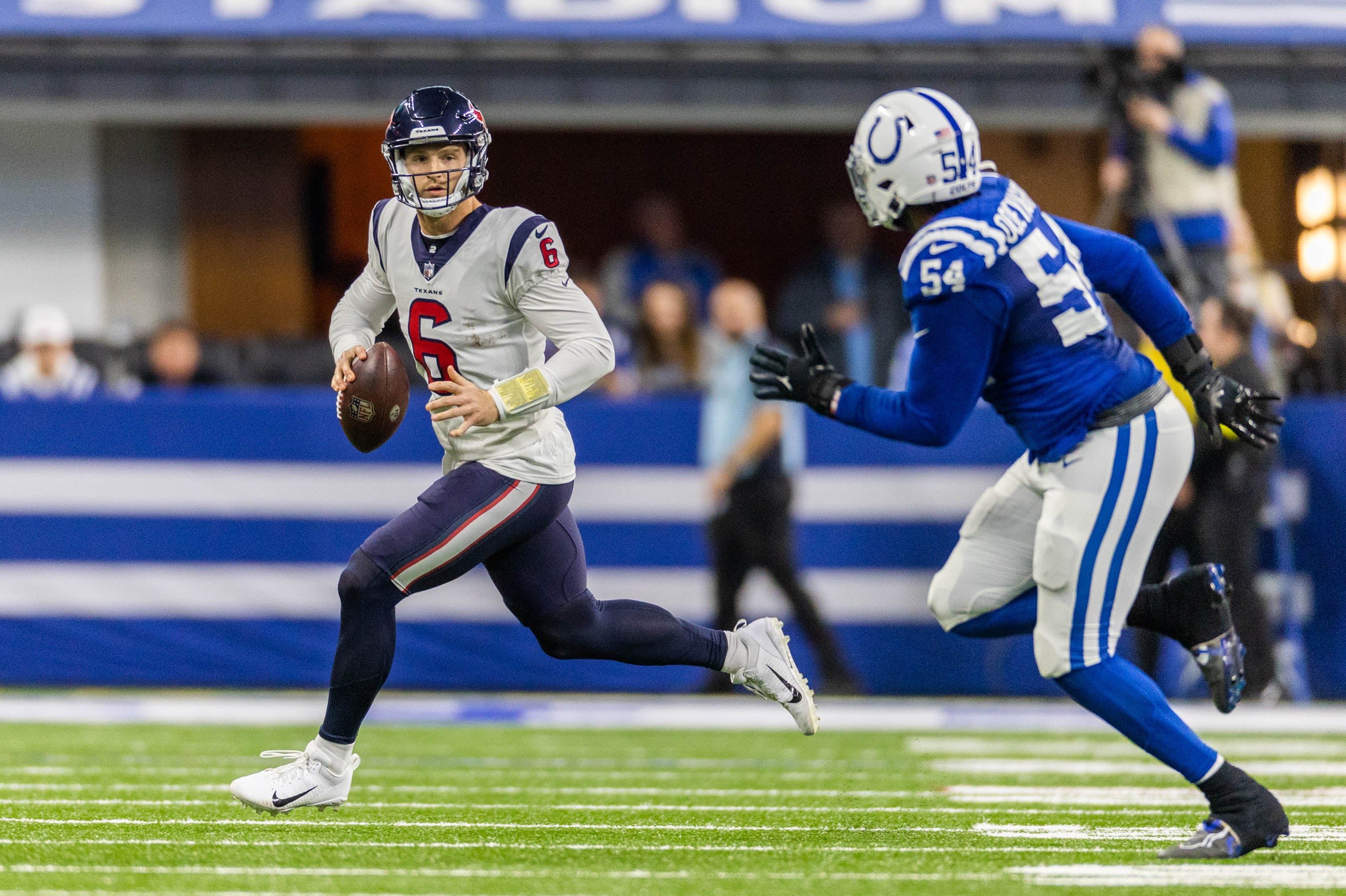 Jan 8, 2023; Indianapolis, Indiana, USA; Houston Texans quarterback Jeff Driskel (6) runs to pass the ball while Indianapolis Colts defensive end Dayo Odeyingbo (54) defends in the first half at Lucas Oil Stadium.