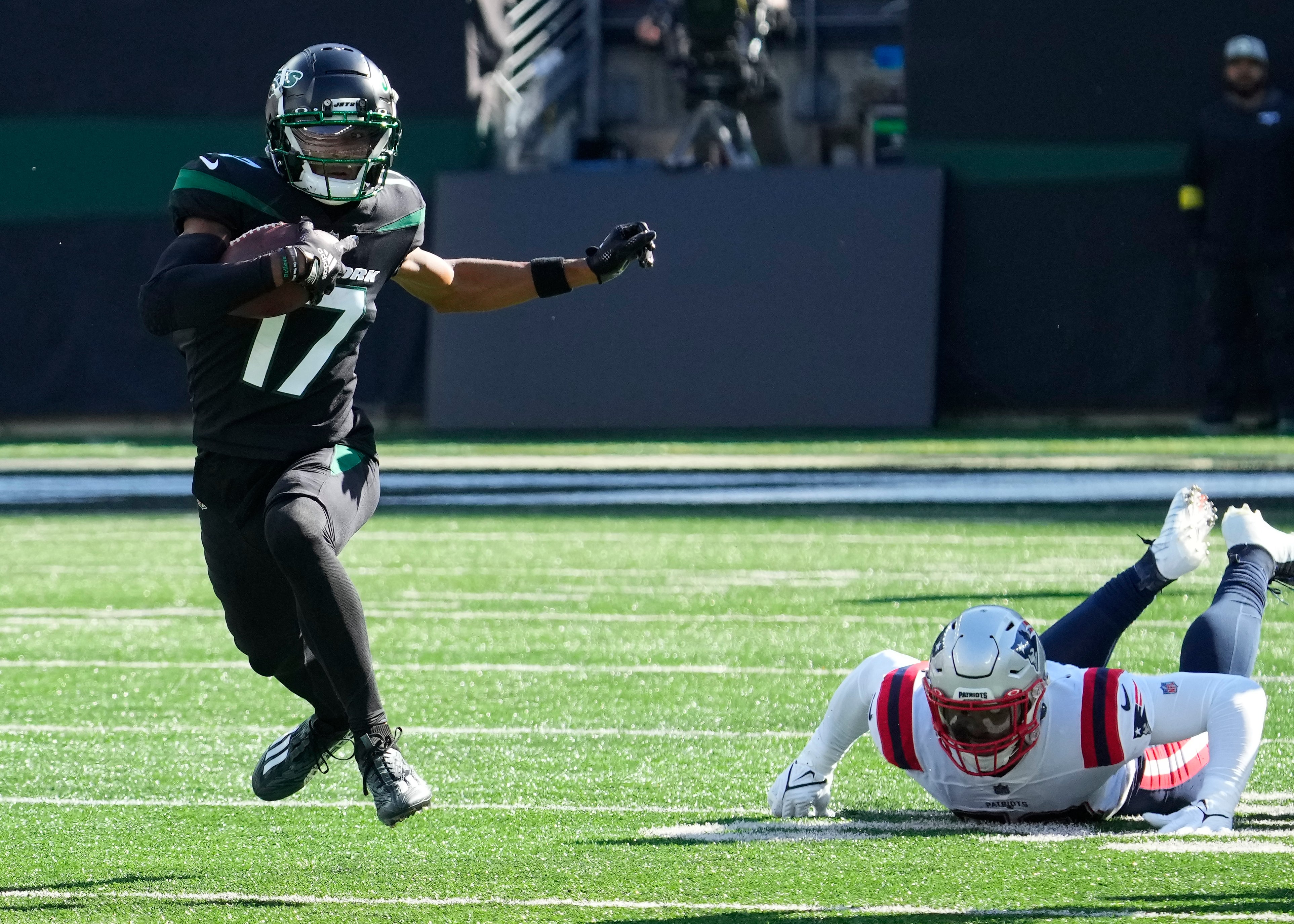 New York Jets wide receiver Garrett Wilson (17) runs past New England Patriots linebacker Anfernee Jennings (58) in the 1st half at MetLife Stadium.