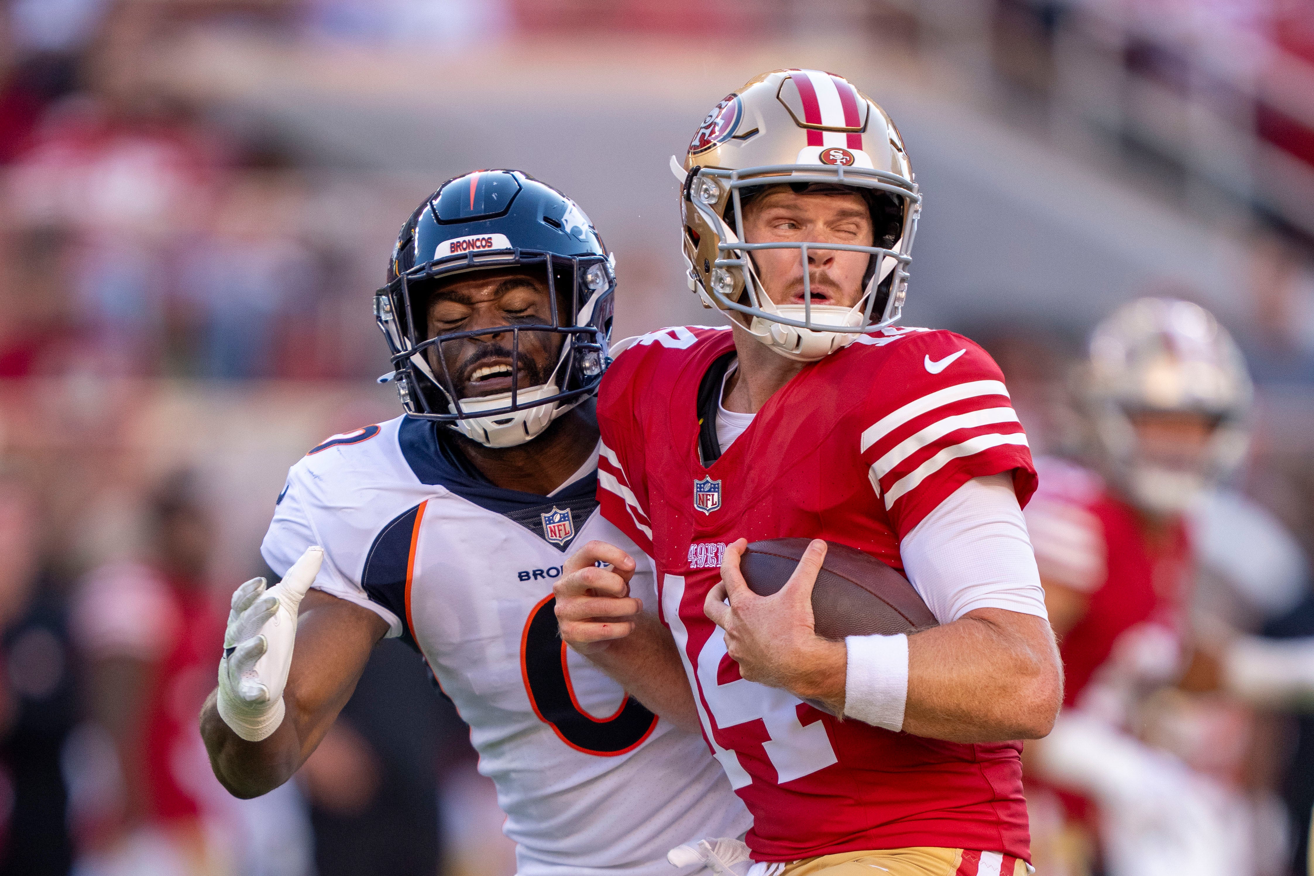 August 19, 2023; Santa Clara, California, USA; San Francisco 49ers quarterback Sam Darnold (14) is tackled by Denver Broncos linebacker Jonathon Cooper (0) during the second quarter at Levi's Stadium. Mandatory Credit: Kyle Terada-USA TODAY Sports