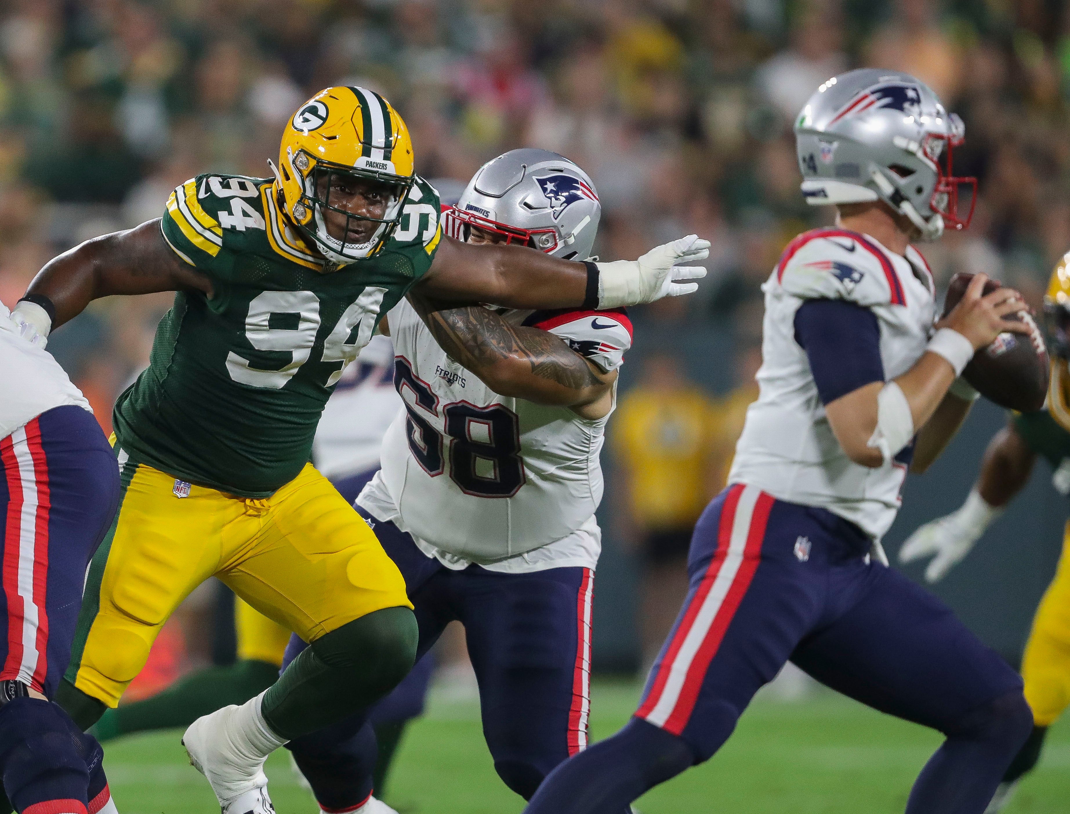 Aug 19, 2023; Green Bay, WI, USA; Green Bay Packers defensive end Karl Brooks (94) rushes New England Patriots quarterback Mac Jones (10) during their preseason football game at Lambeau Field. Tork Mason-USA TODAY Sports