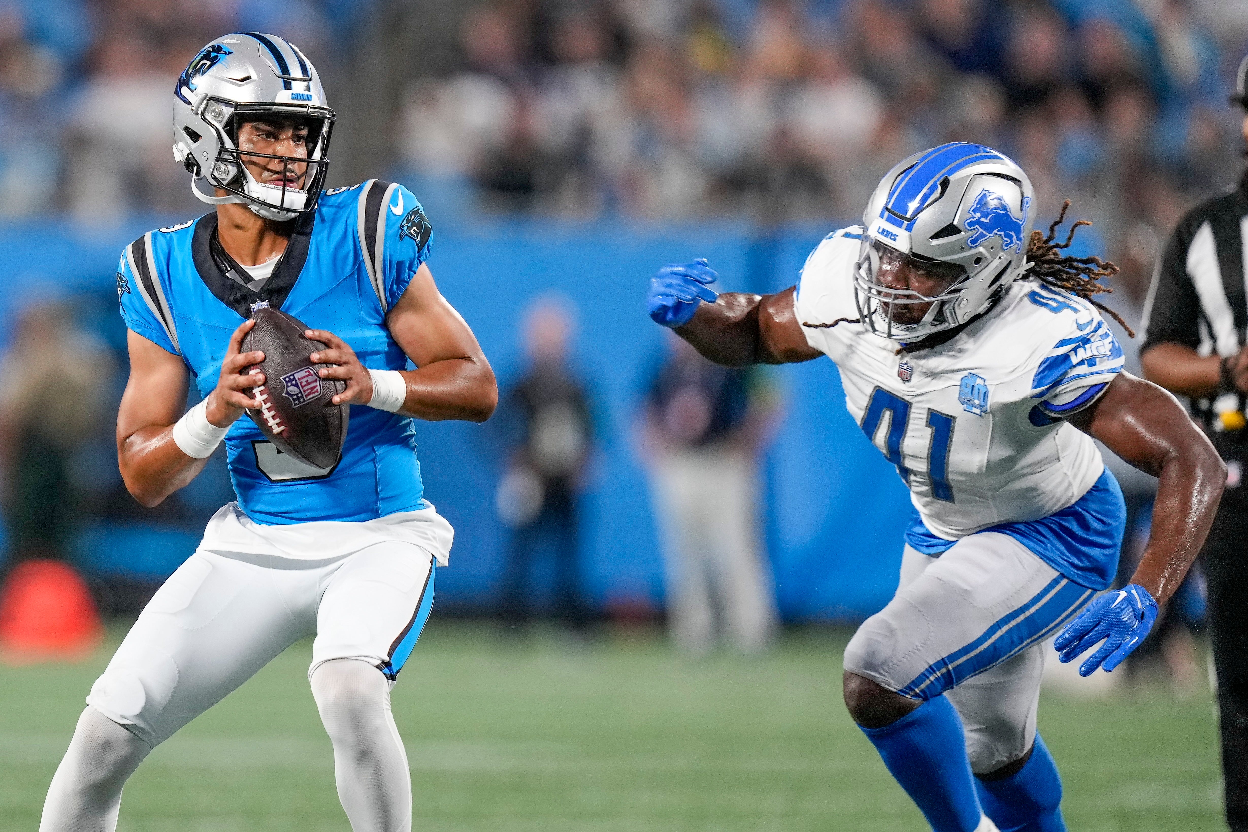 Aug 25, 2023; Charlotte, North Carolina, USA; Carolina Panthers quarterback Bryce Young (9) drops back under pressure from Detroit Lions linebacker James Houston (41) during the first quarter at Bank of America Stadium. Mandatory Credit: Jim Dedmon-USA TODAY Sports