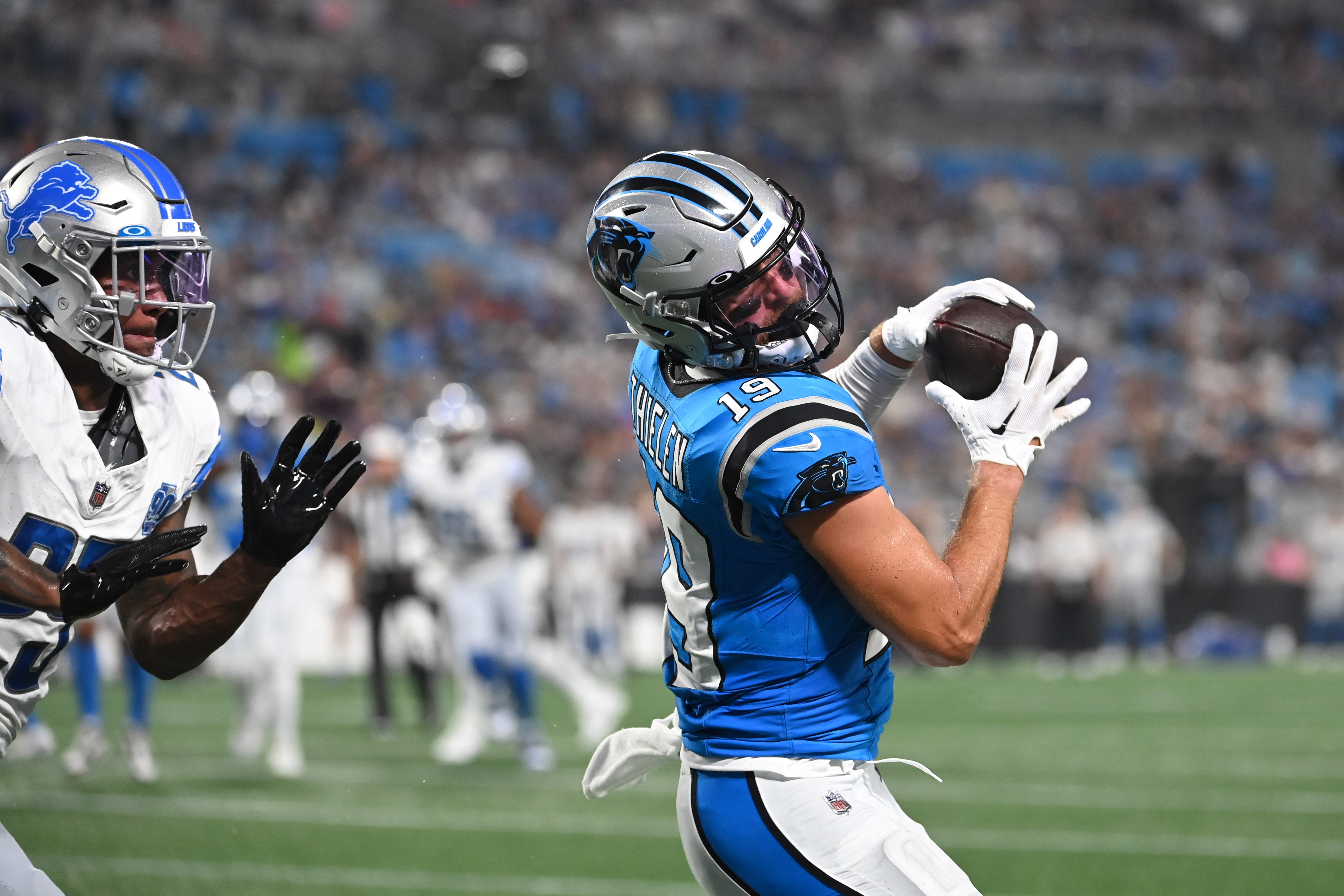 Aug 25, 2023; Charlotte, North Carolina, USA; Carolina Panthers wide receiver Adam Thielen (19) catches a touchdown pass as Detroit Lions cornerback Will Harris (25) defends in the first quarter at Bank of America Stadium. Mandatory Credit: Bob Donnan-USA TODAY Sports