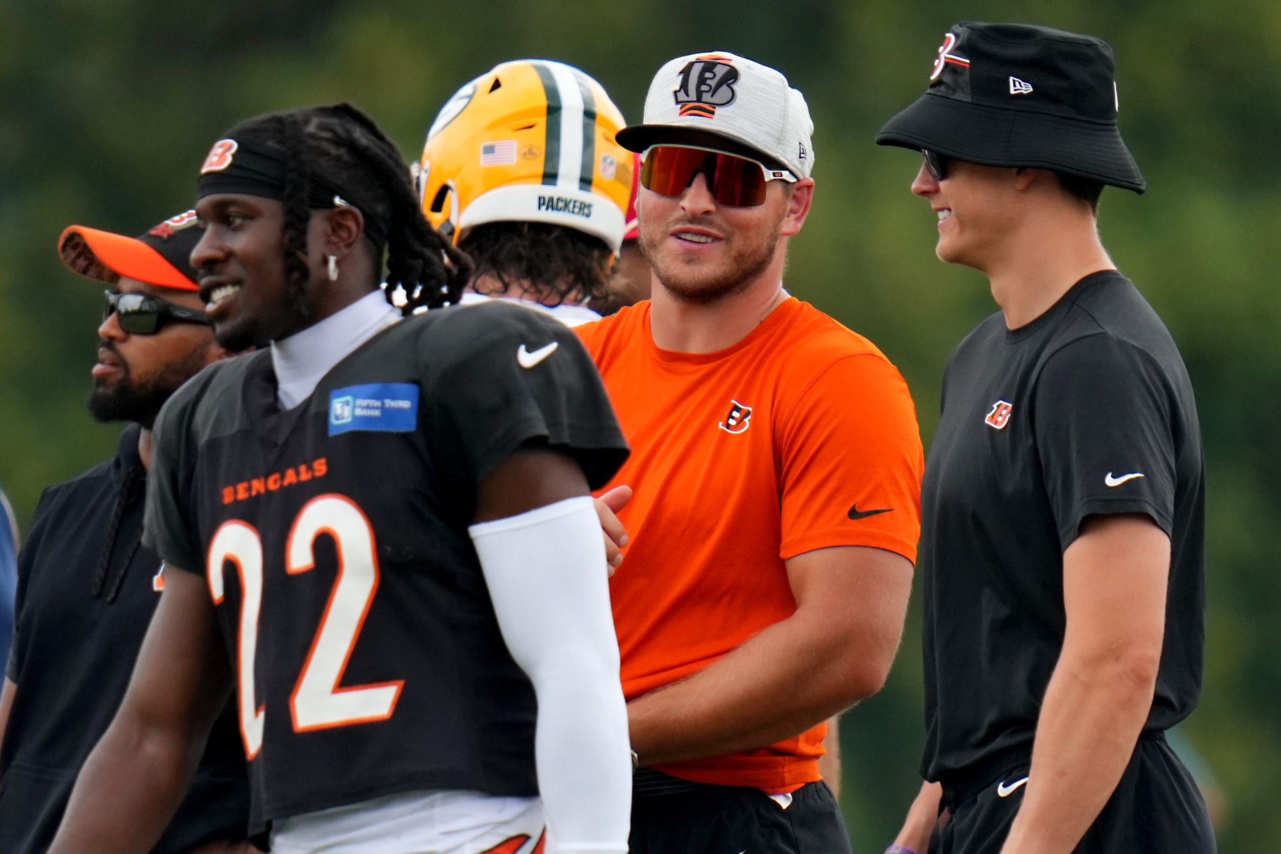 Cincinnati Bengals linebacker Logan Wilson (55), center, talks with Cincinnati Bengals quarterback Joe Burrow (9), right, during a joint practice between the Green Bay Packers and the Cincinnati Bengals, Wednesday, Aug. 9, 2023, at the practice fields next to Paycor Stadium in Cincinnati.