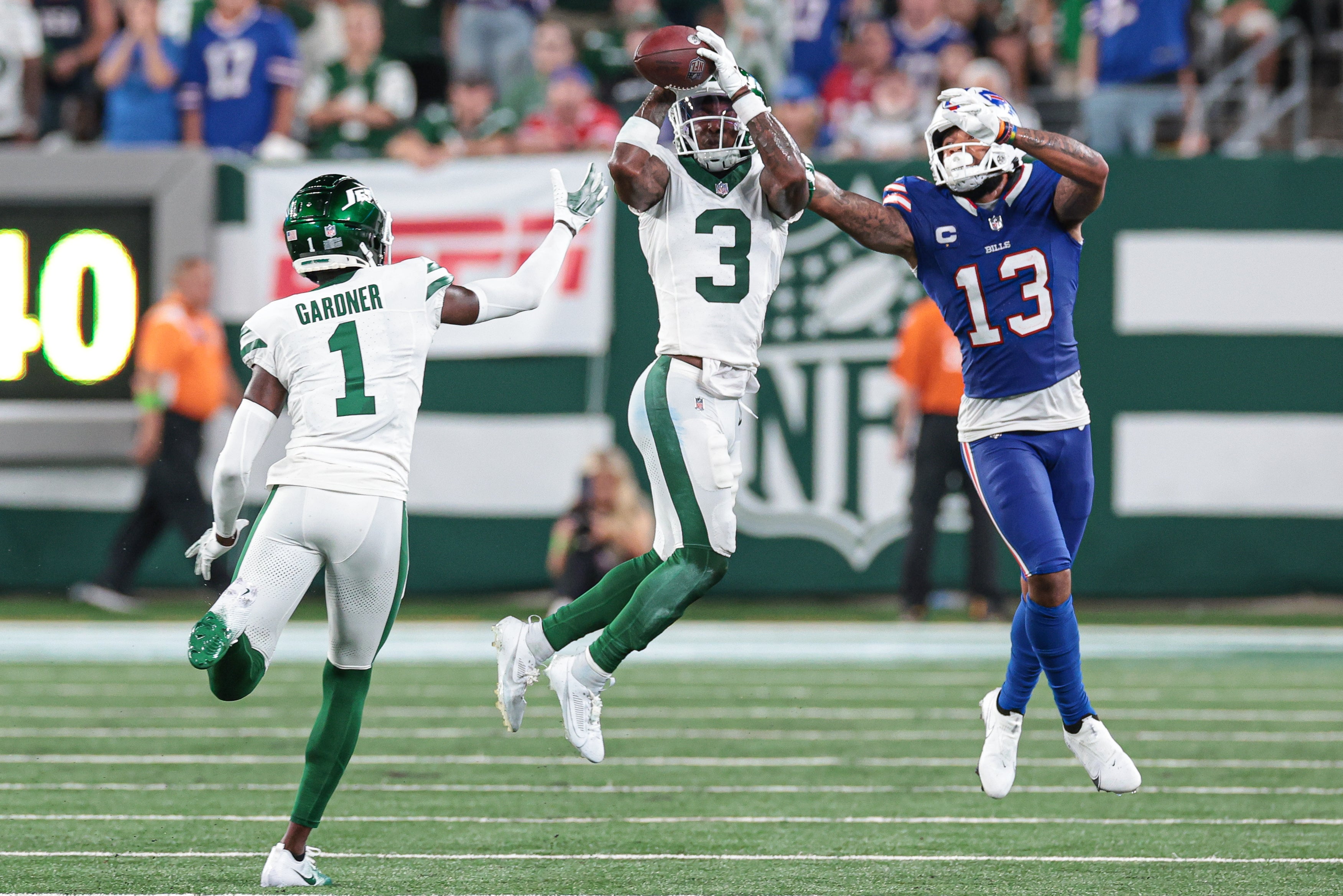 Jets safety Jordan Whitehead (3) intercepts a pass intended for Buffalo Bills wide receiver Gabe Davis (13) in front of cornerback Sauce Gardner (1) during the second half at MetLife Stadium.